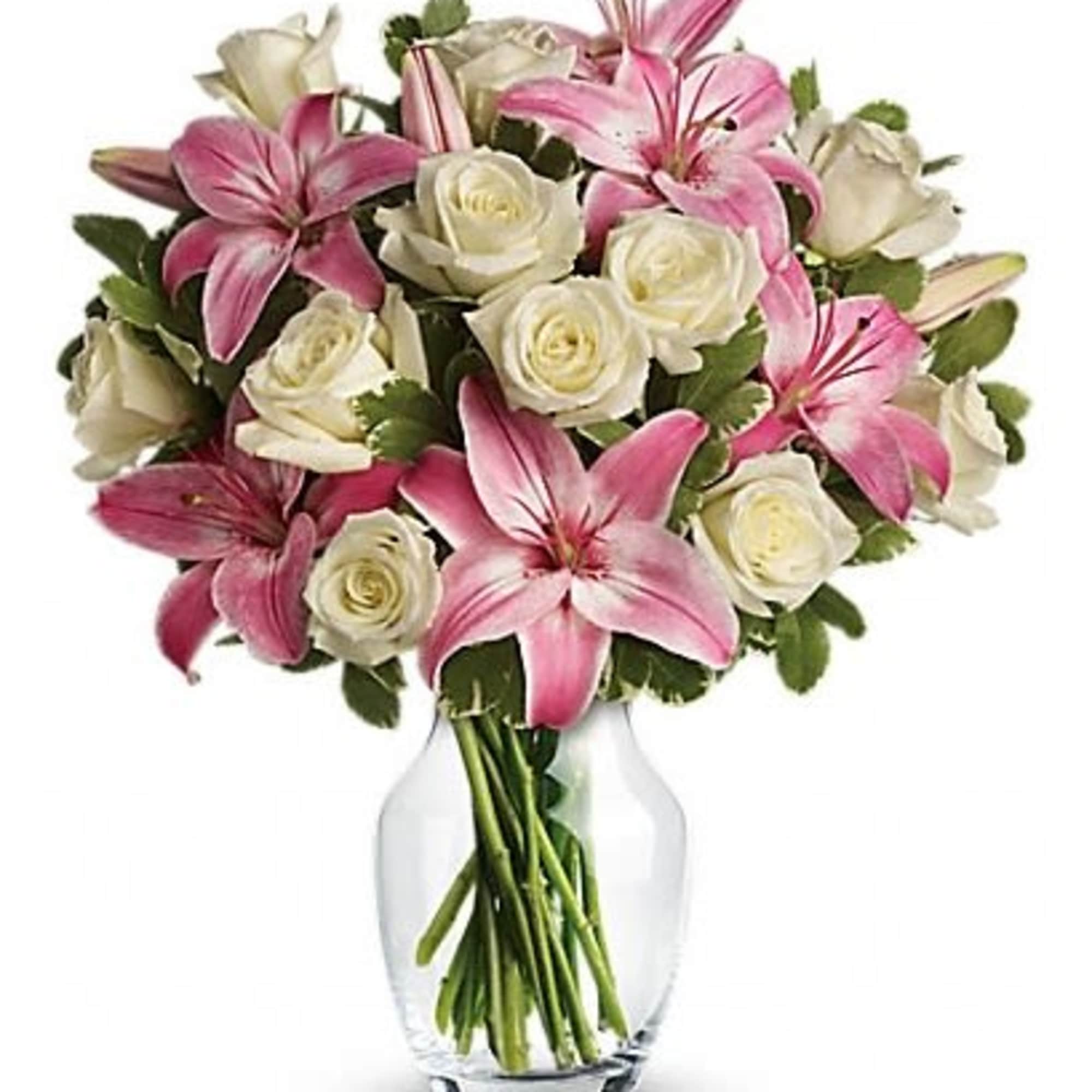 Pink lilies and white roses in a clear glass vase