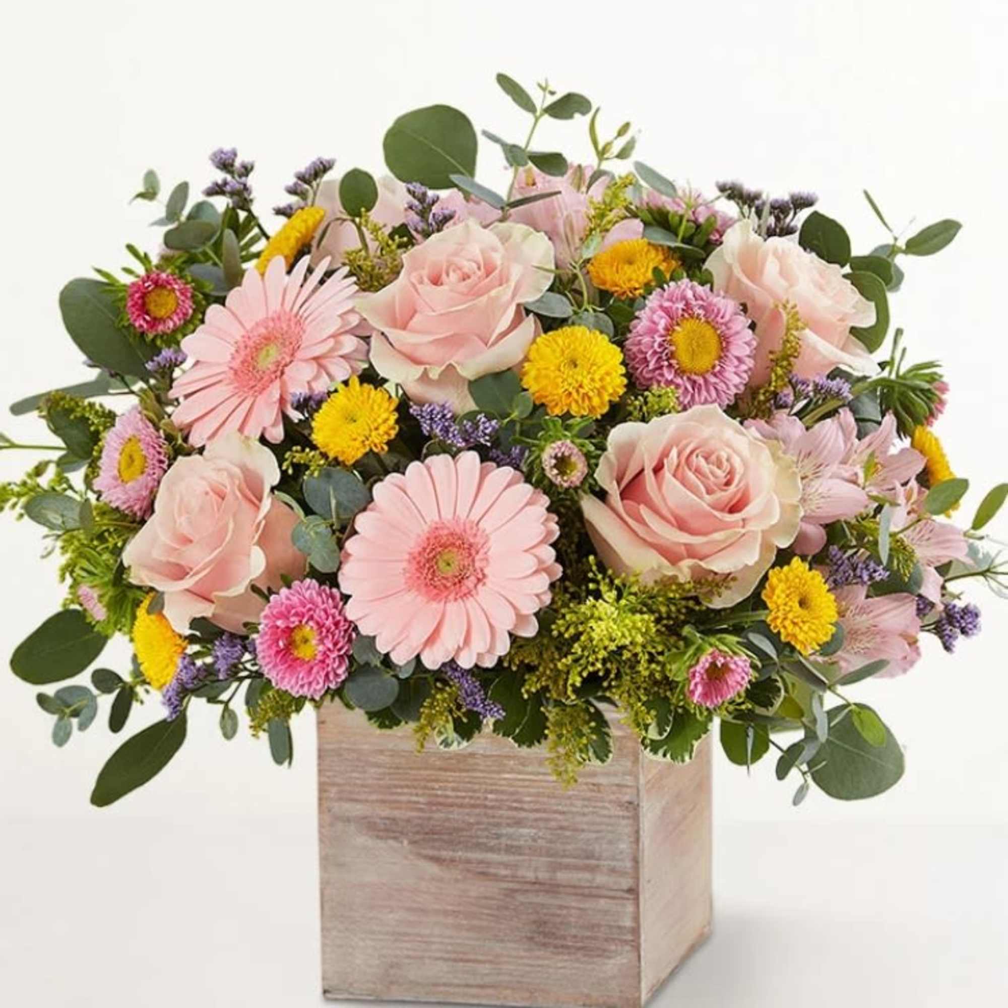 Pink roses and daisies arranged in a wooden box