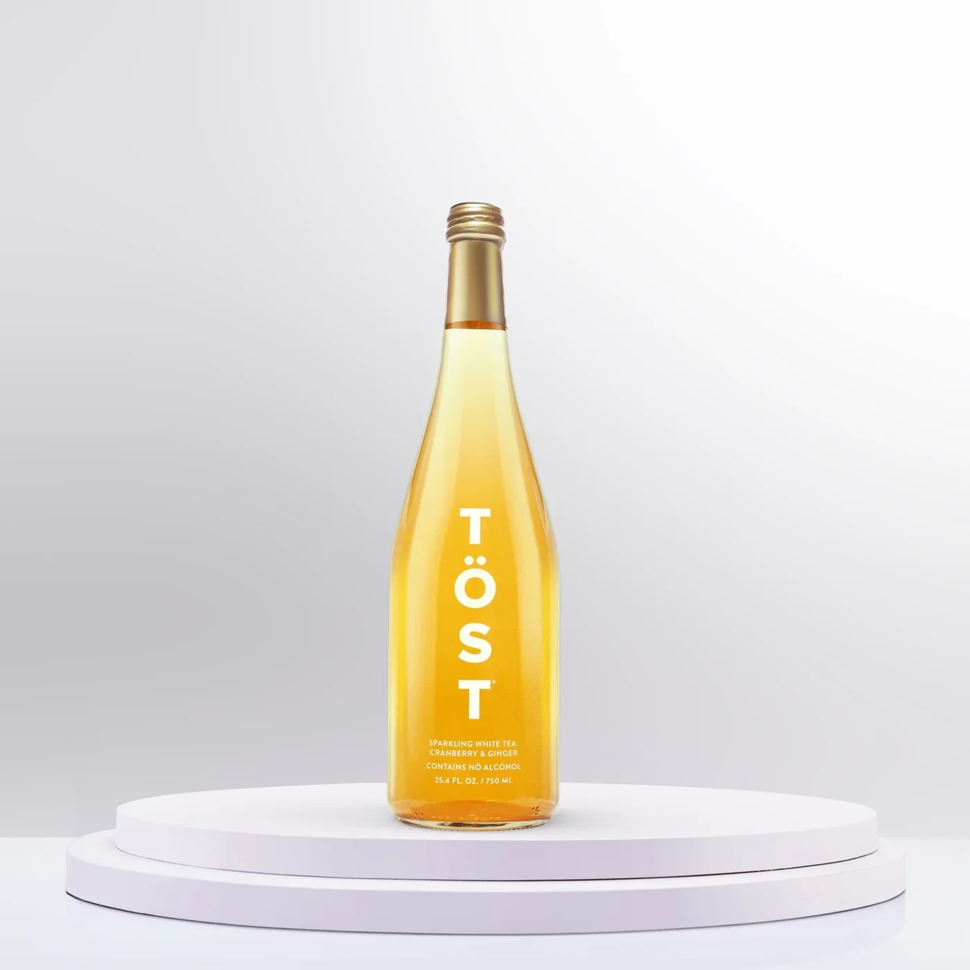 Bottle of sparkling white tea on a white pedestal