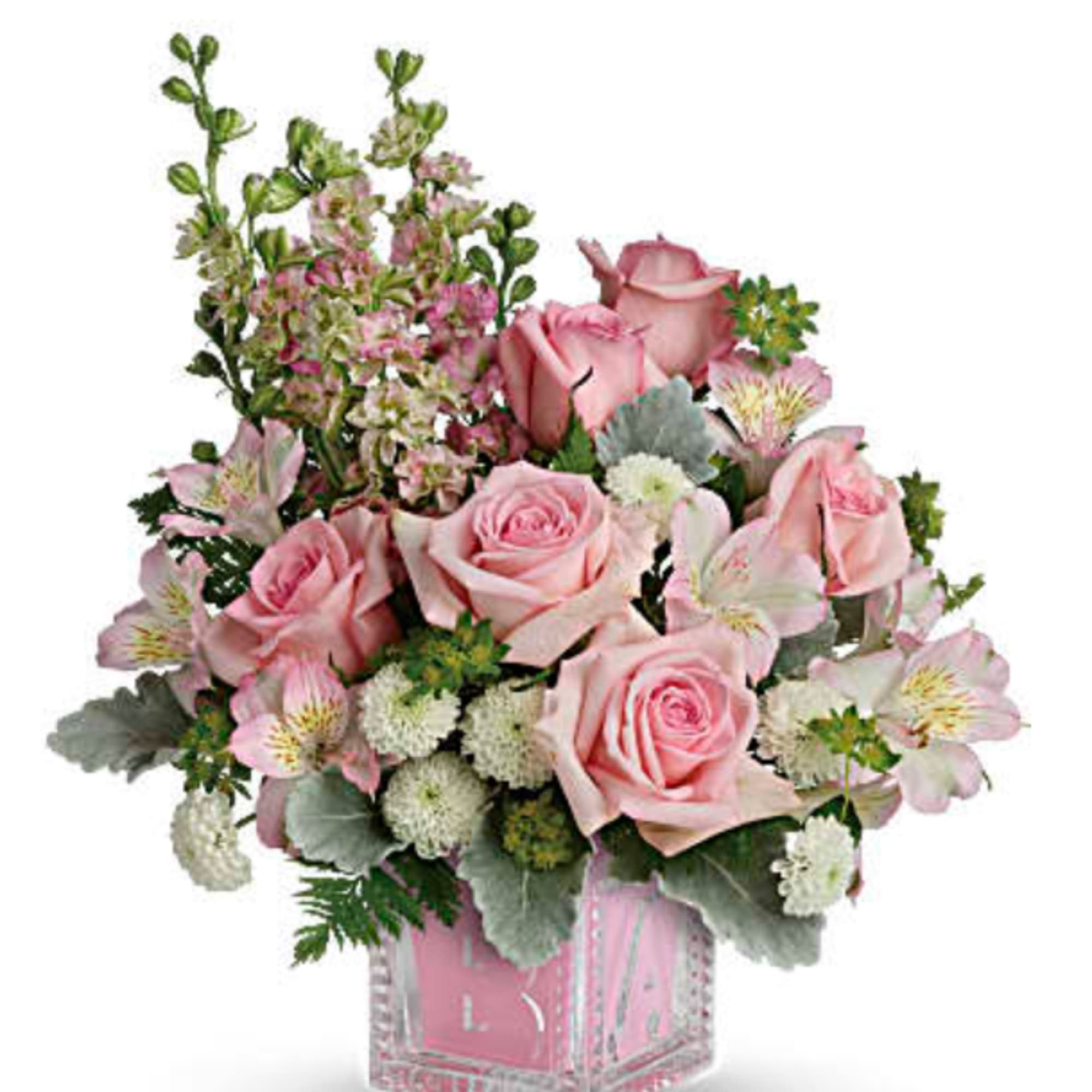 Pink roses and alstroemeria arranged in a clear square vase