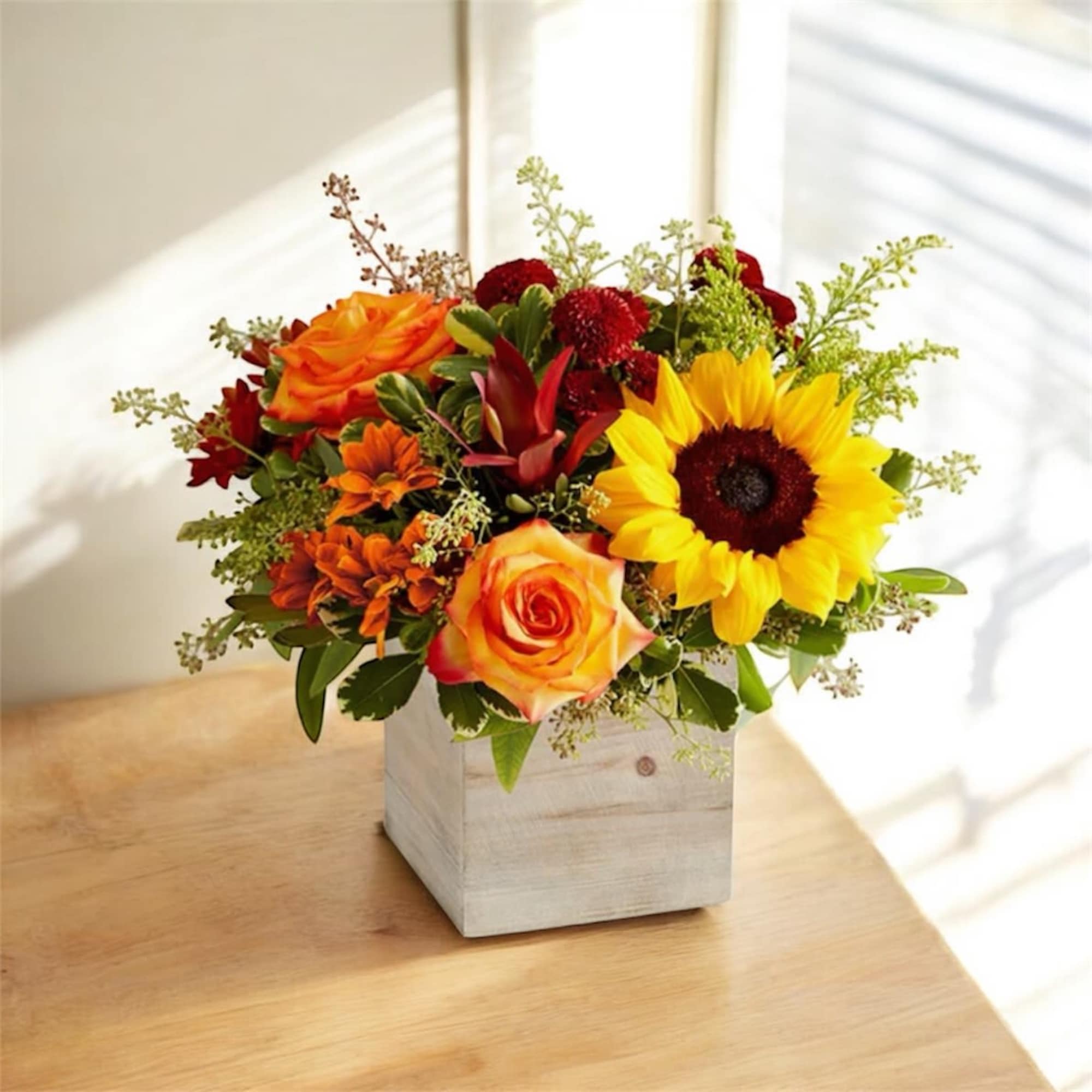 Sunflower and orange rose arrangement in a white wooden box