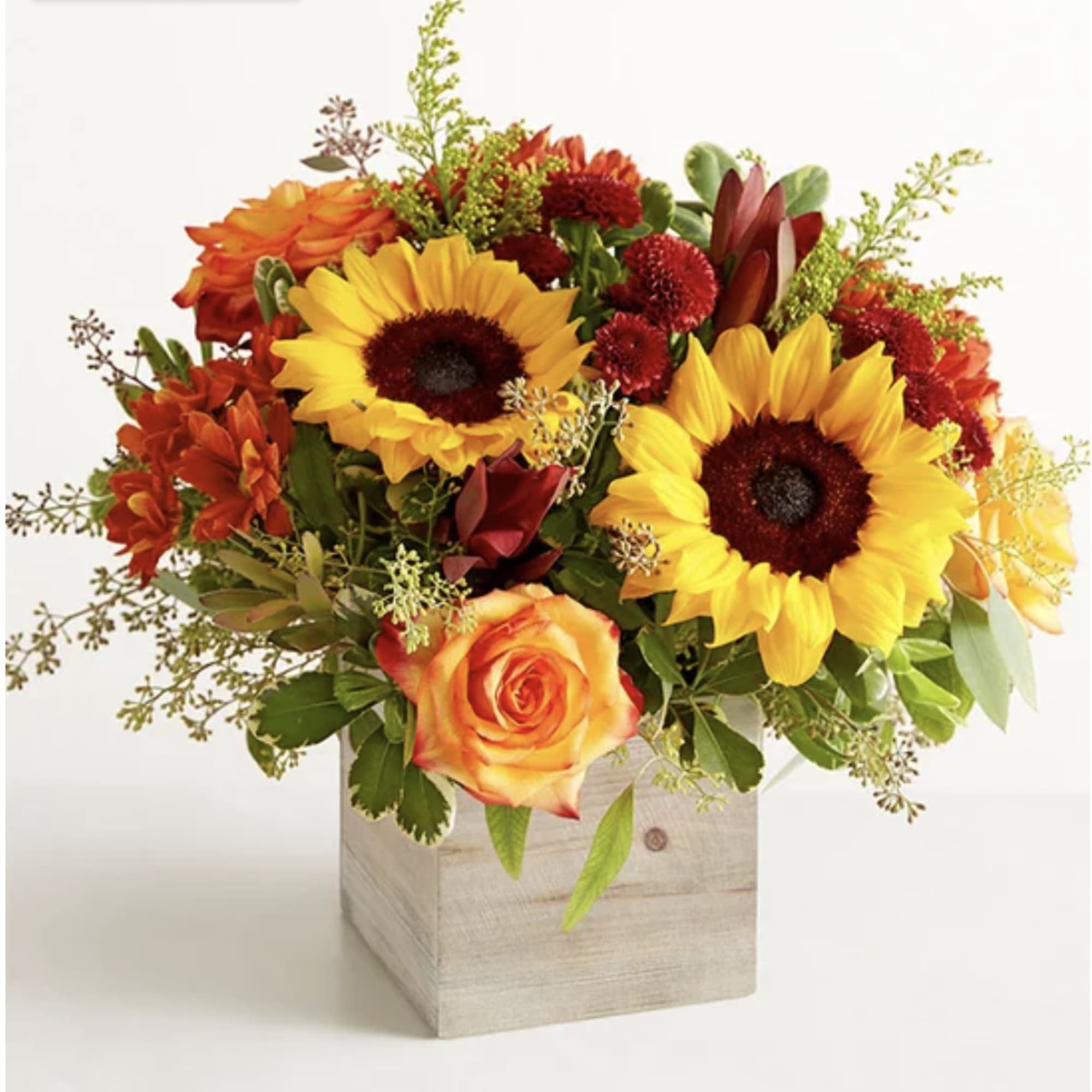 Sunflowers and orange roses arranged in a wooden cube vase