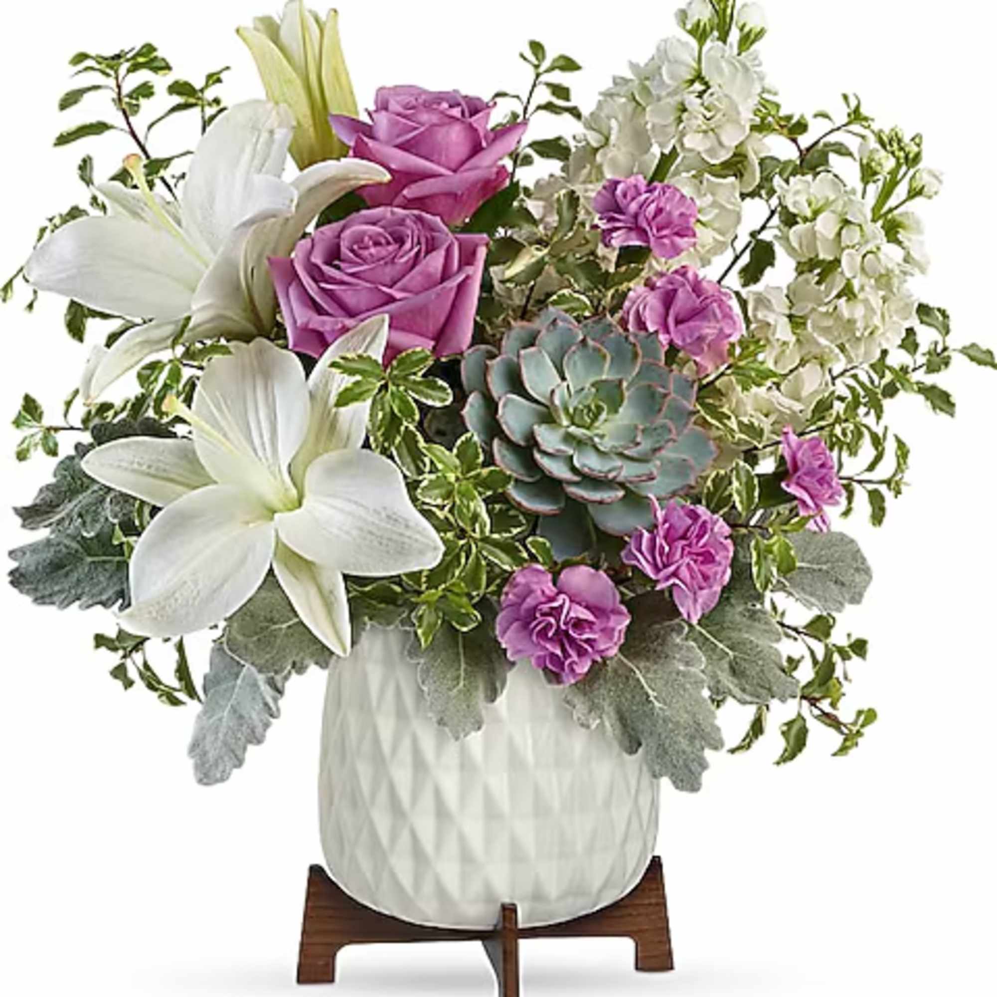 White lilies and purple roses arranged in a white vase with a succulent accent