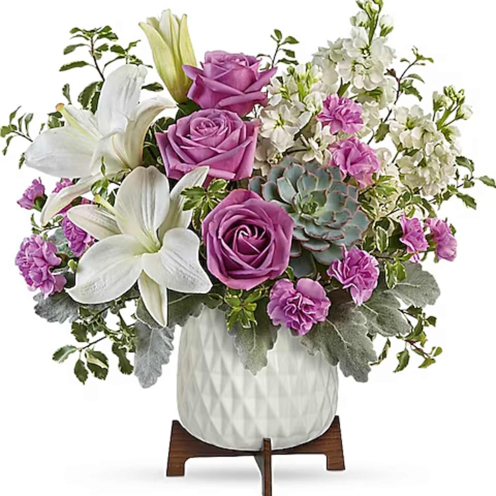 Purple roses and white lilies in a white vase with a succulent accent