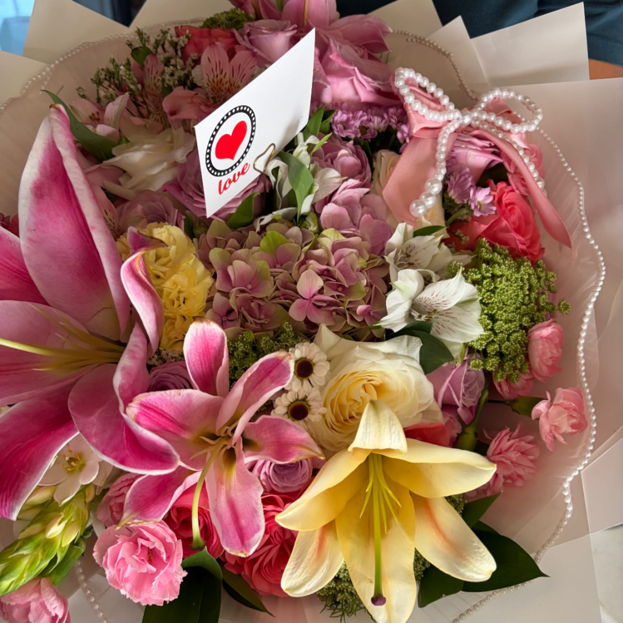 Pink and yellow mixed bouquet with lilies, roses, and hydrangeas
