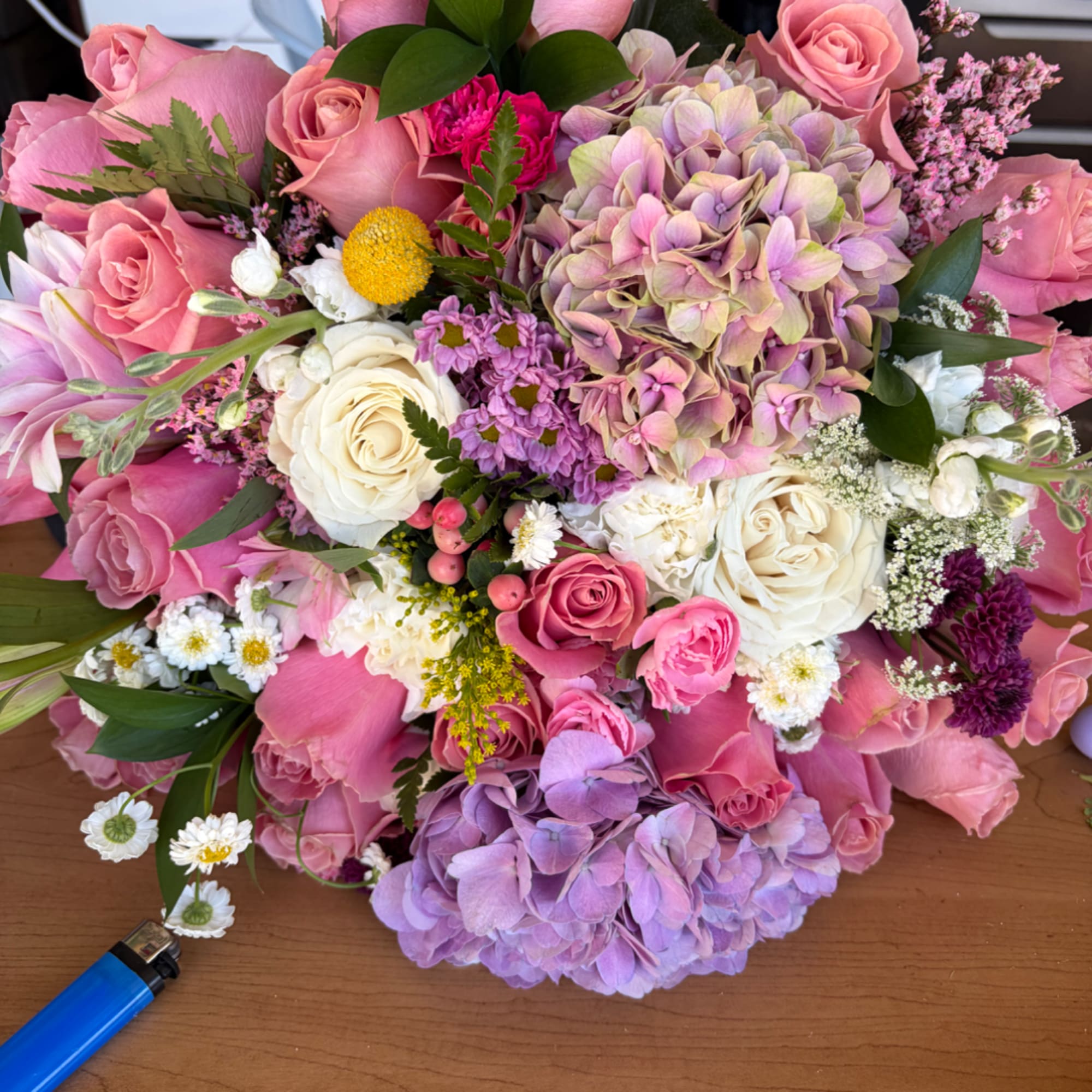 Pink and lavender bouquet with roses, hydrangeas, and small white flowers