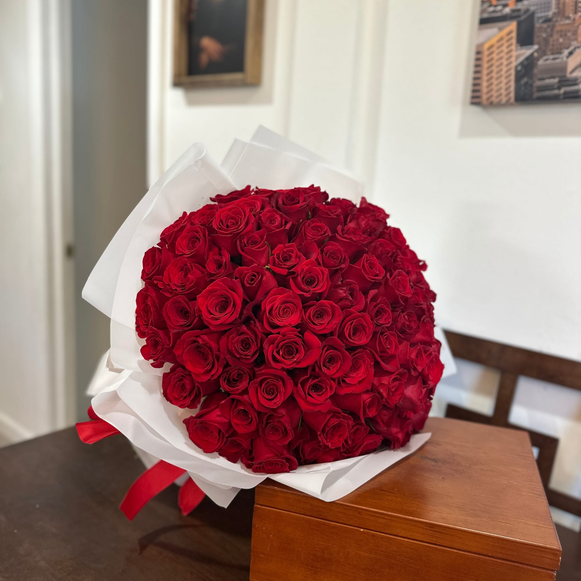 Large bouquet of red roses wrapped in white paper with a red ribbon, photo 4 of 7