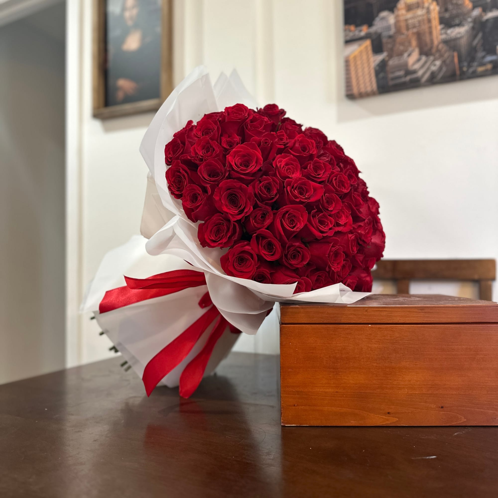 Large bouquet of red roses wrapped in white paper with a red ribbon, photo 6 of 7
