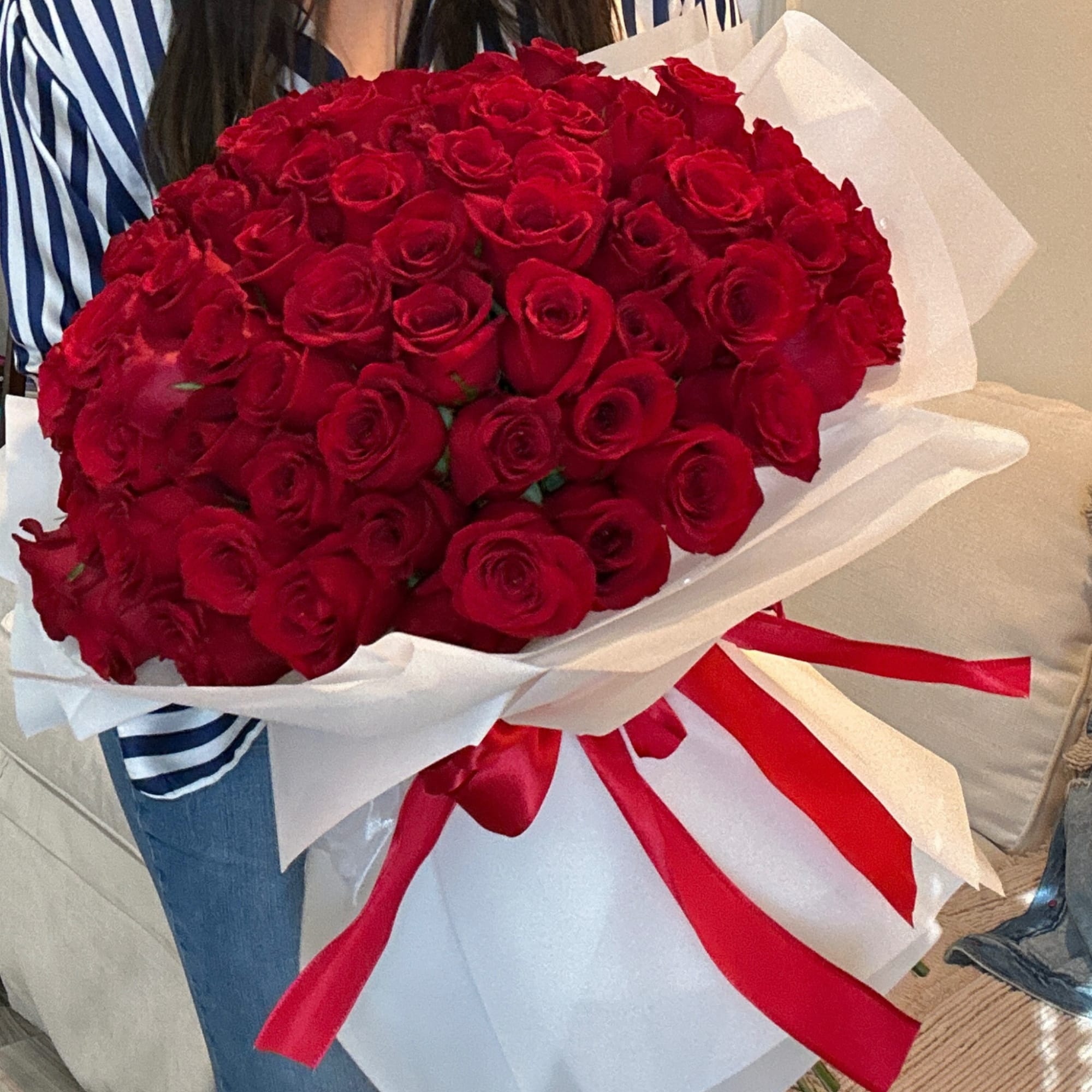 Large bouquet of red roses wrapped in white paper with a red ribbon, photo 7 of 7
