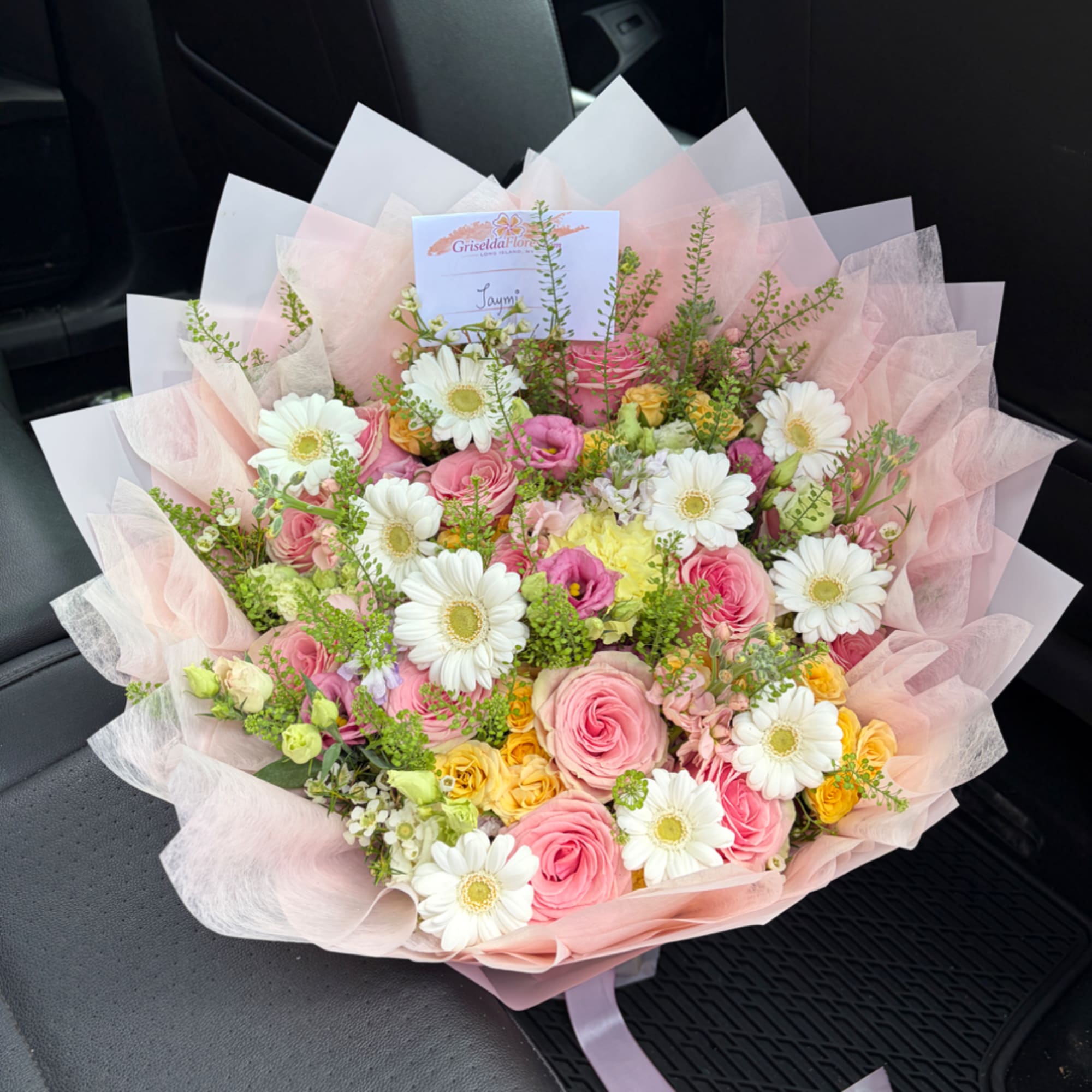 Pink and white mixed flower bouquet wrapped in pale tissue paper