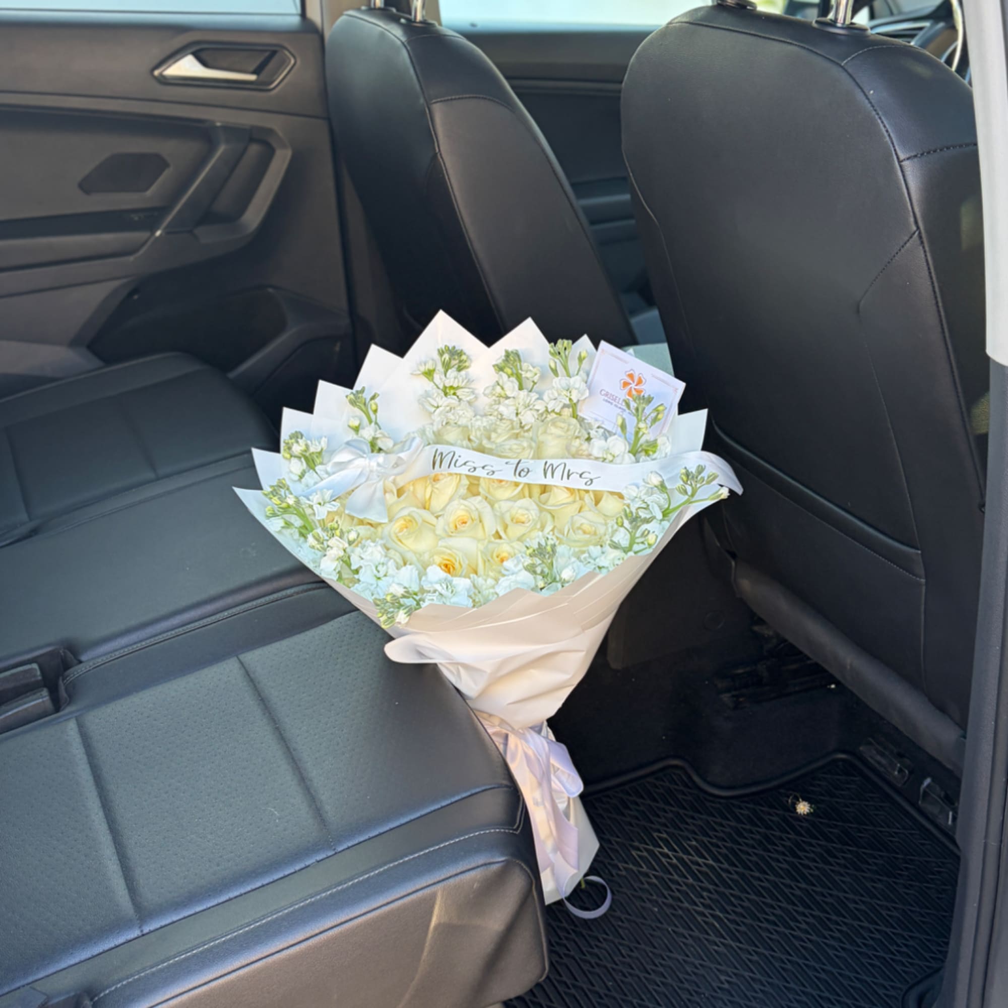 Bouquet of pale yellow roses and white flowers wrapped in cream paper