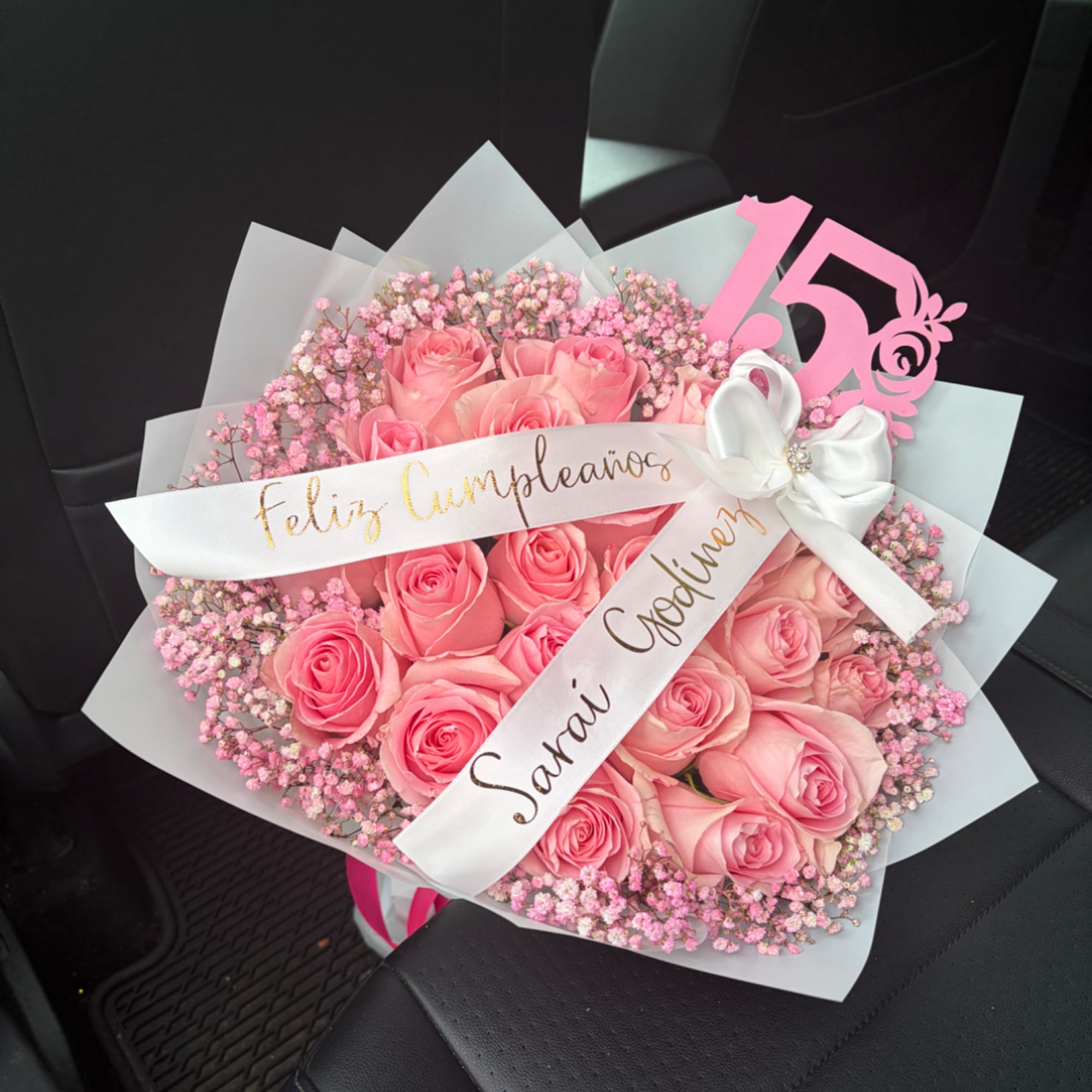 Pink rose bouquet with baby’s breath, wrapped in white paper and ribbon
