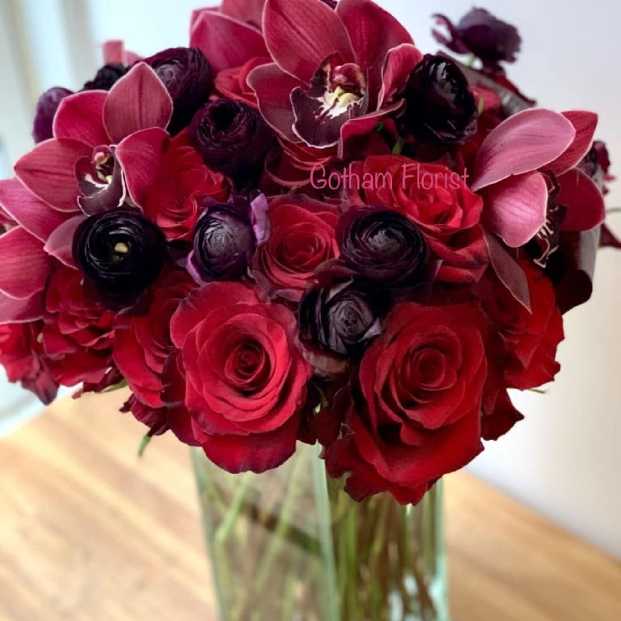 Red and burgundy bouquet in a clear glass vase