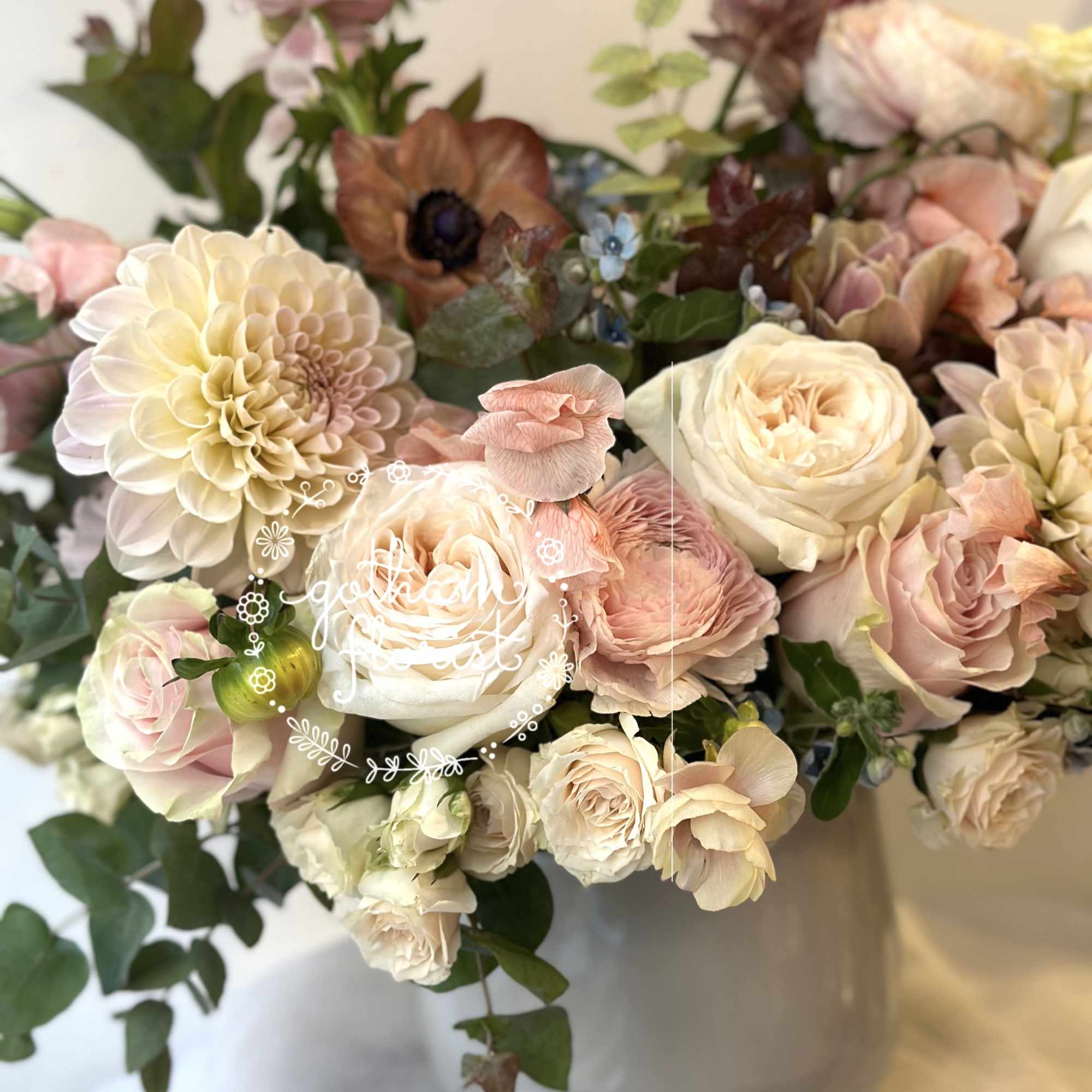 Bouquet of blush and cream flowers in a white vase