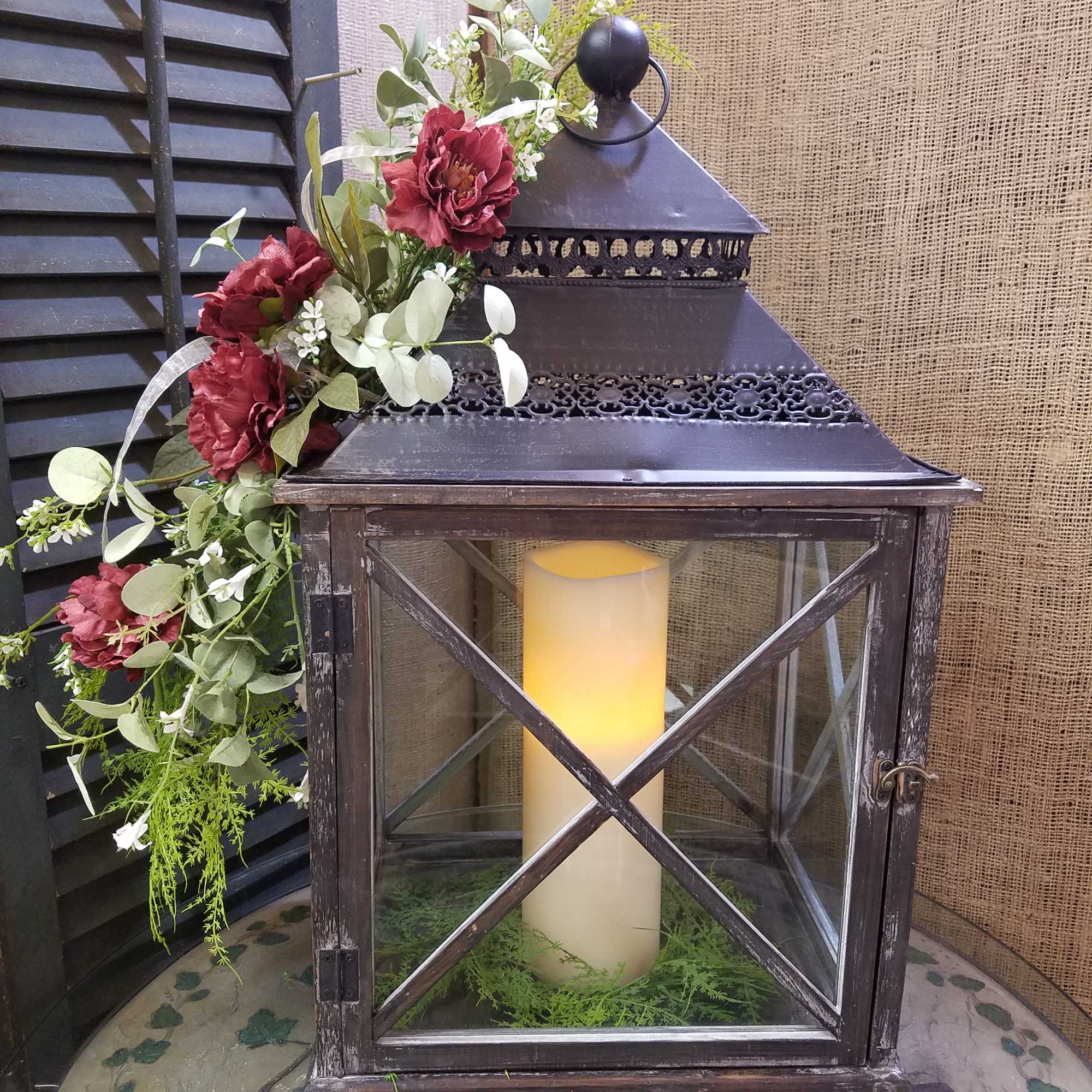 Lantern with a candle and burgundy floral garland