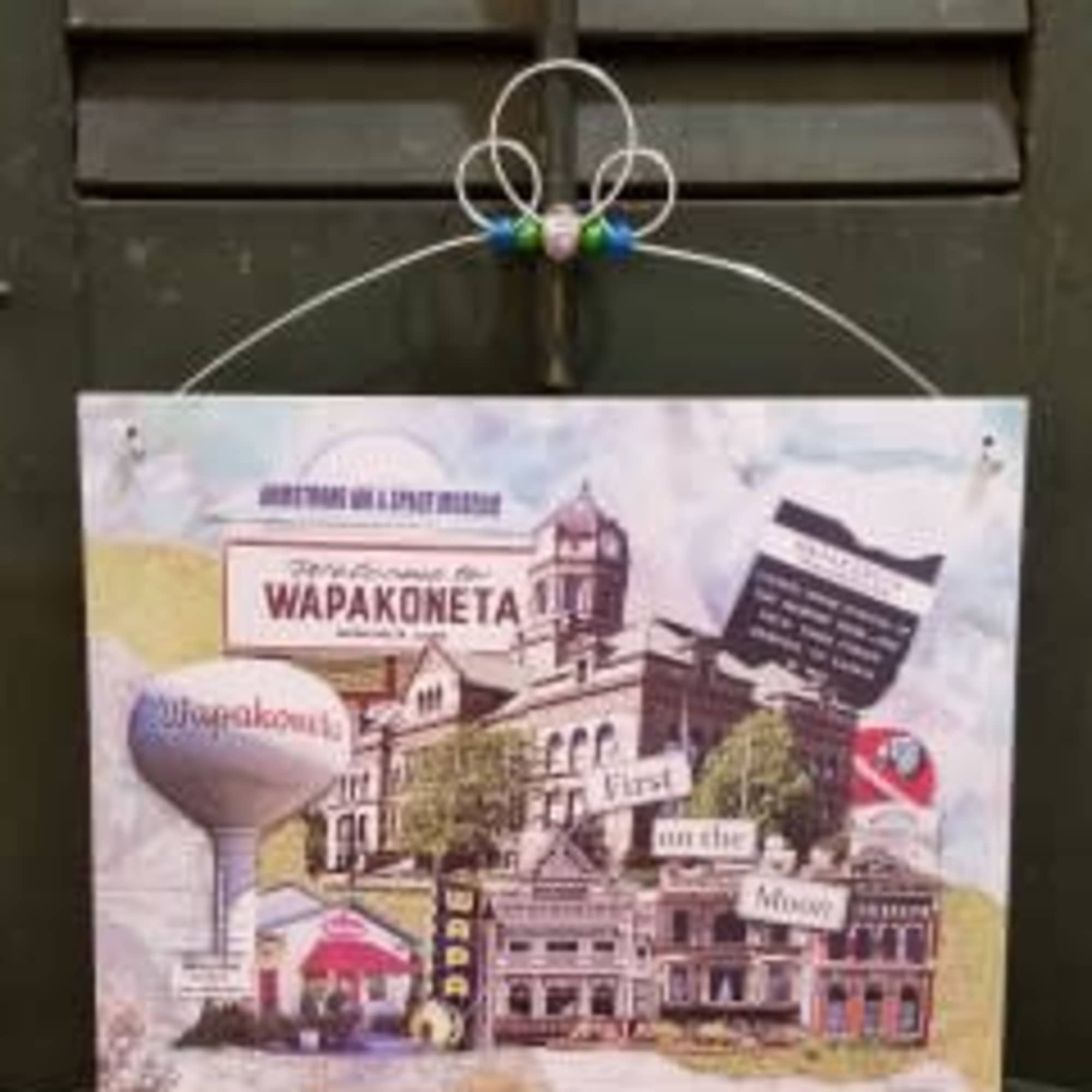 Decorative hanging sign with a city collage and text