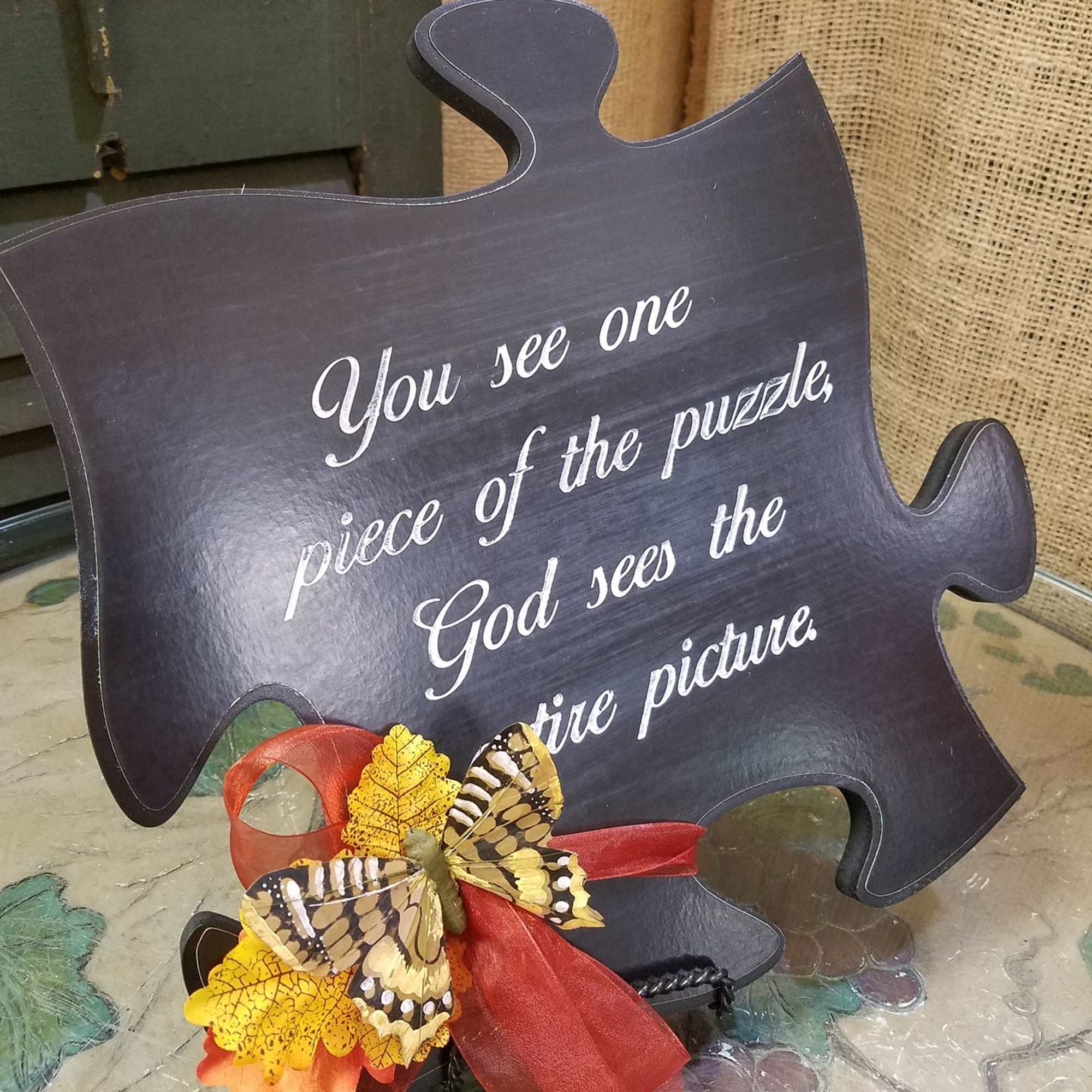 Puzzle-piece sign with a butterfly and ribbon decoration