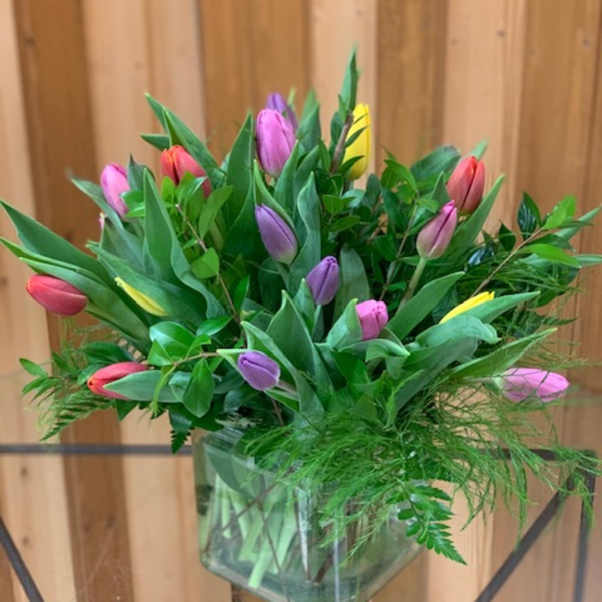 Bouquet of multicolored tulips in a clear glass vase