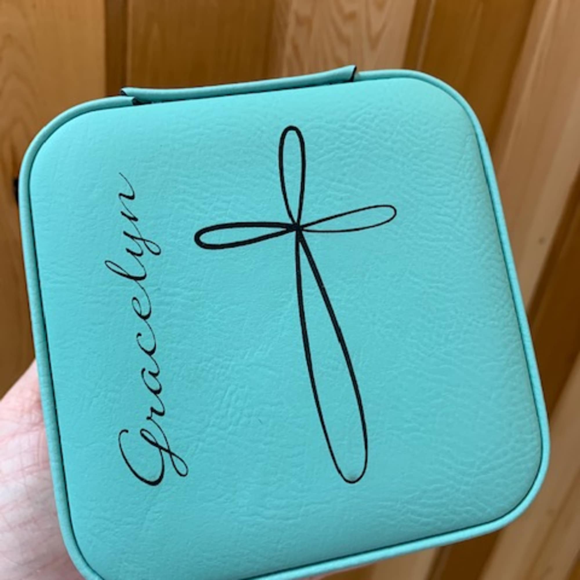 Turquoise gift box with a black bow graphic and cursive text
