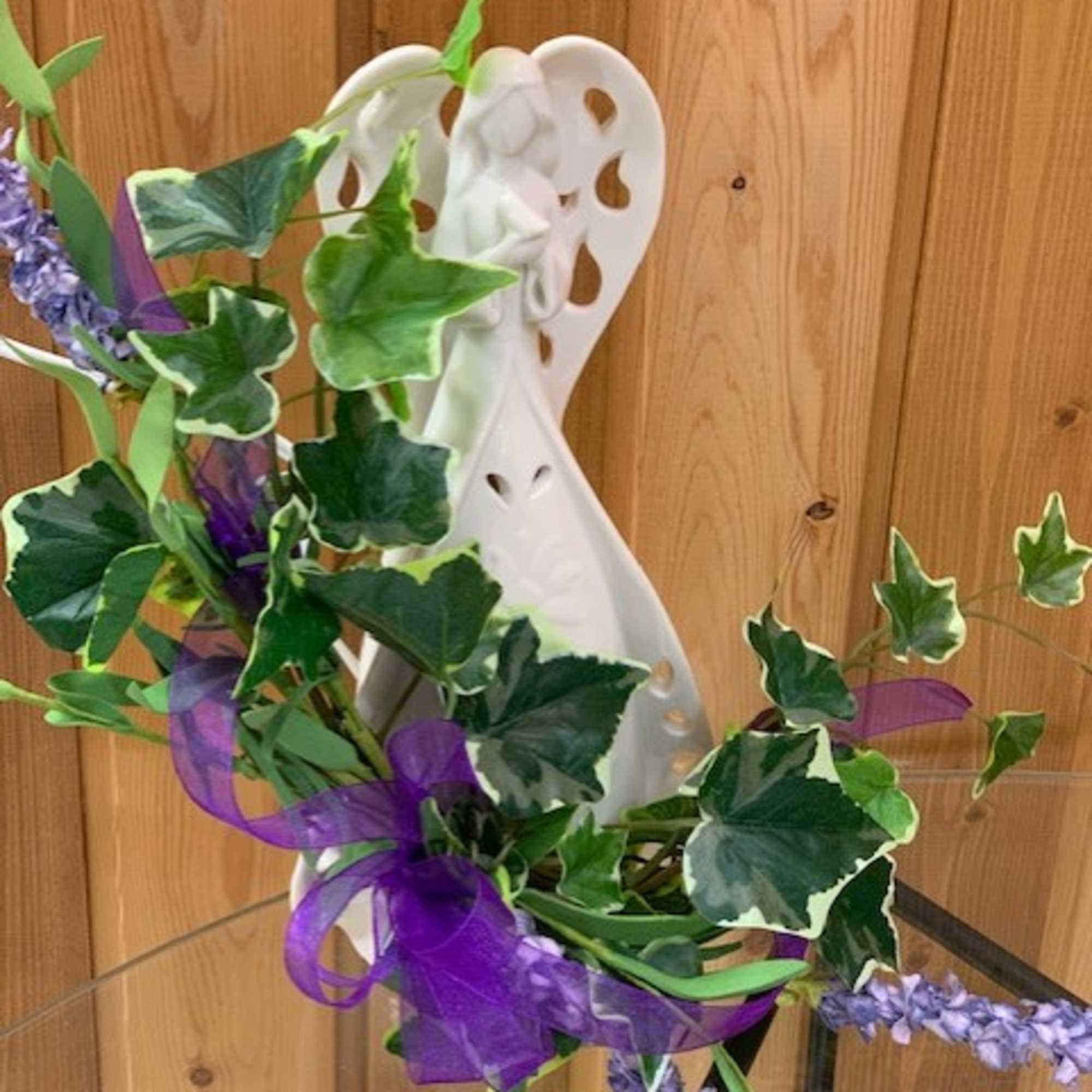 White angel figurine with ivy and purple ribbon accents