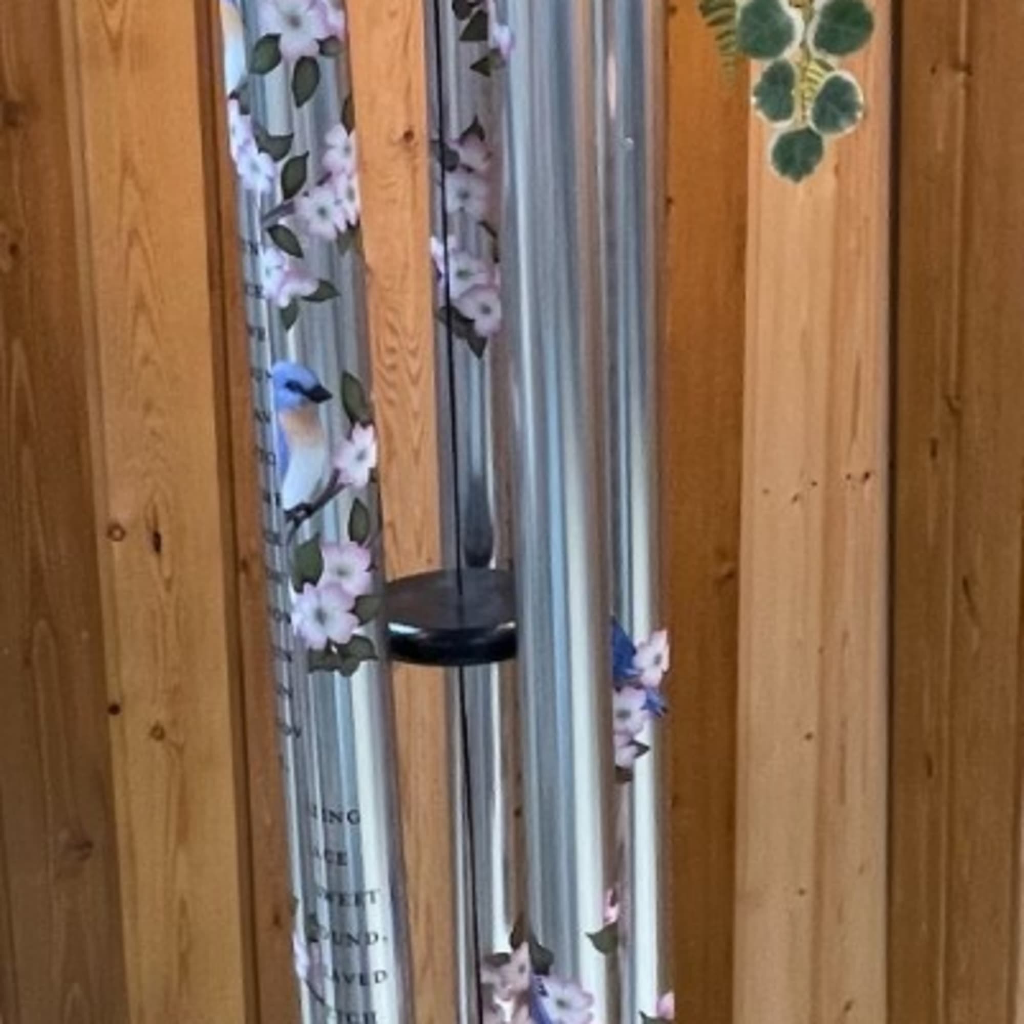 Decorative wind chime with floral accents hanging indoors
