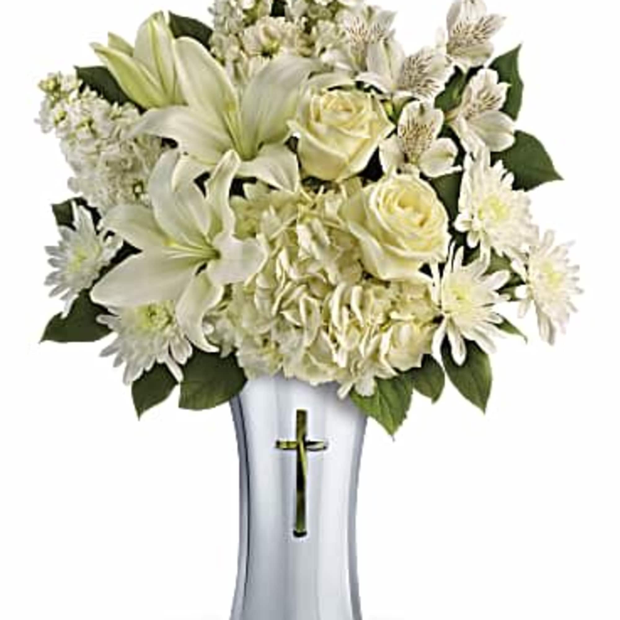 White floral arrangement in a silver vase with a cross