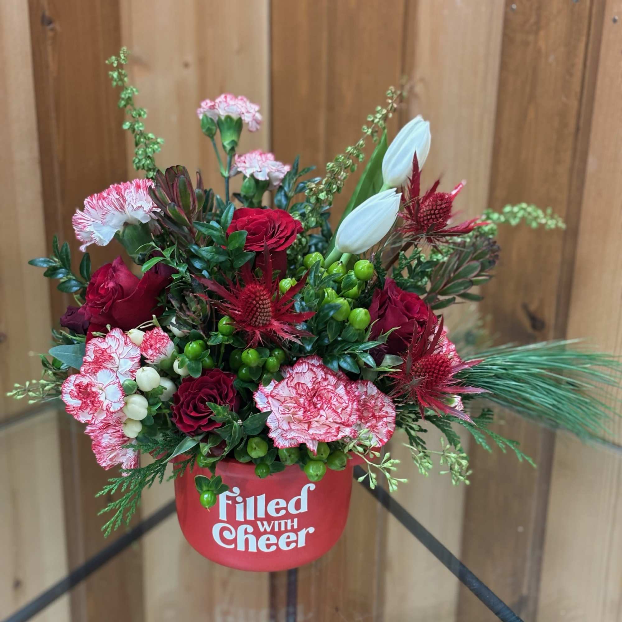 Red and pink floral arrangement in a red container