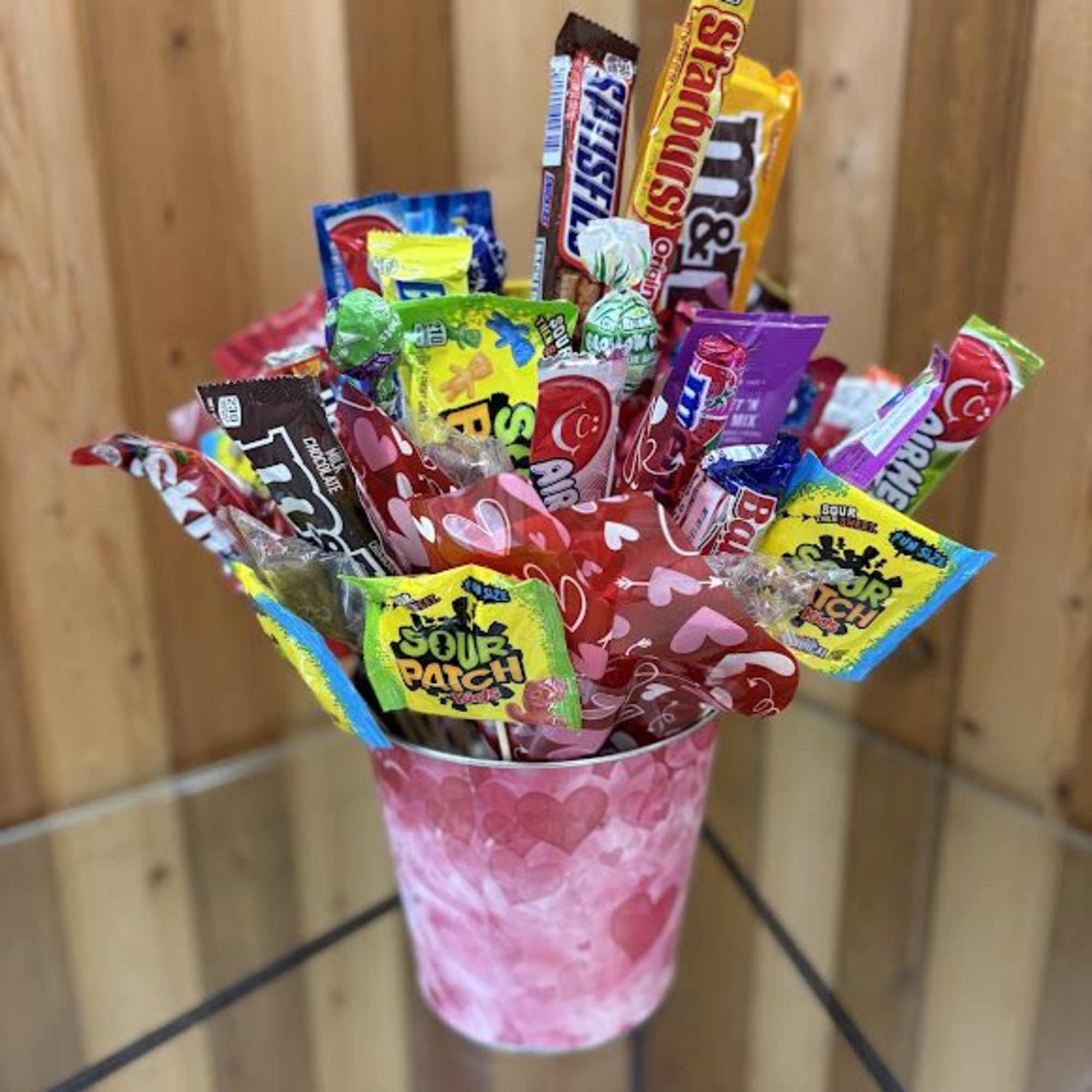 Candy bouquet in a pink heart-patterned cup