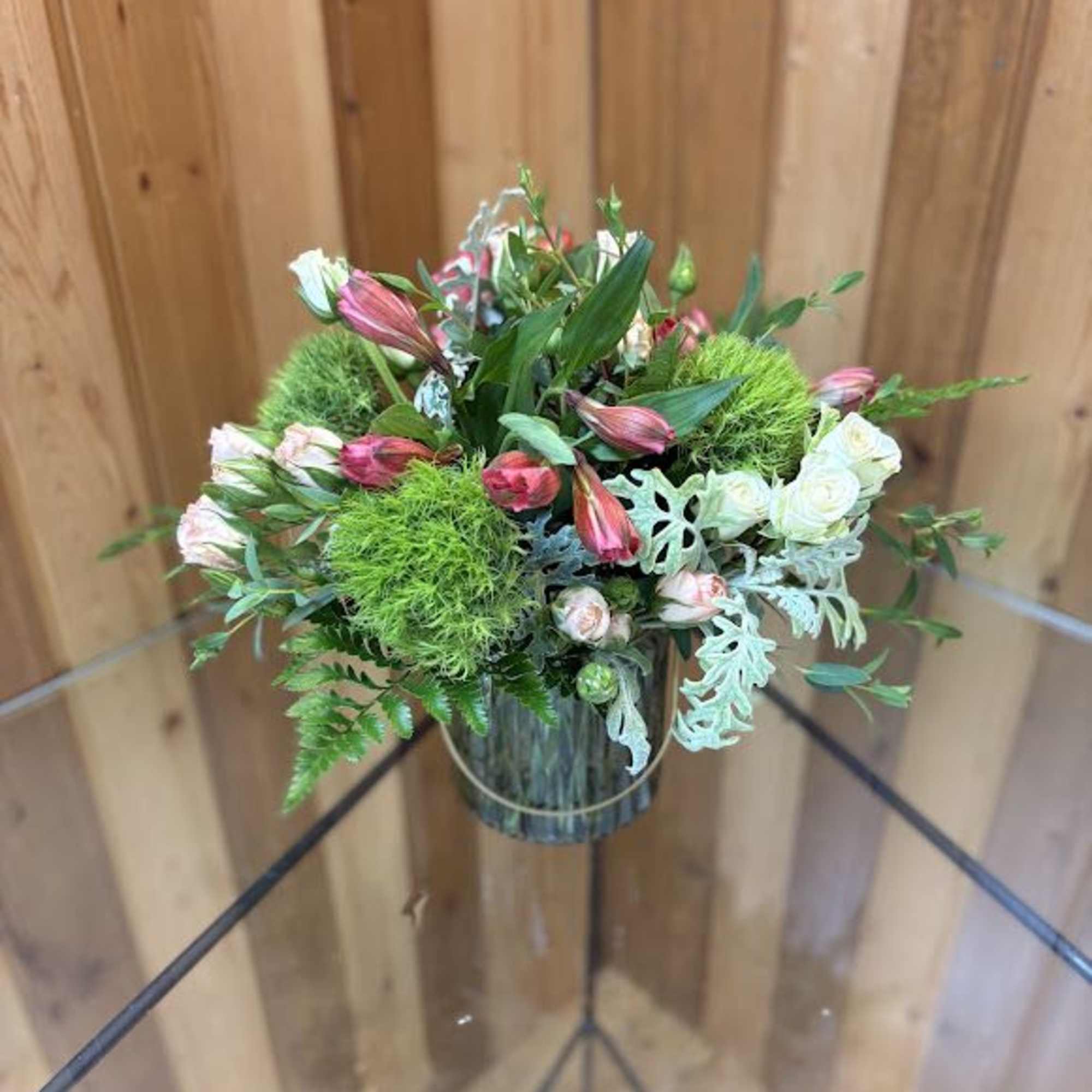 Compact bouquet of pink and white flowers in a glass vase