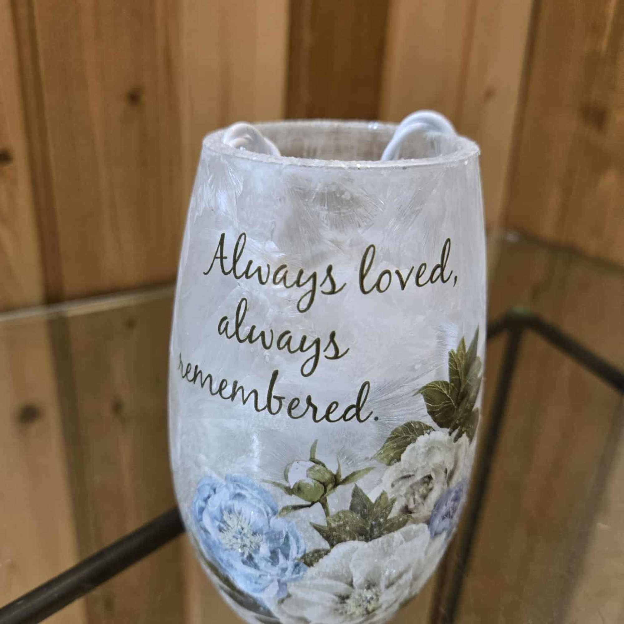 Decorative memorial candle holder with floral print and the words "Always loved, always remembered."
