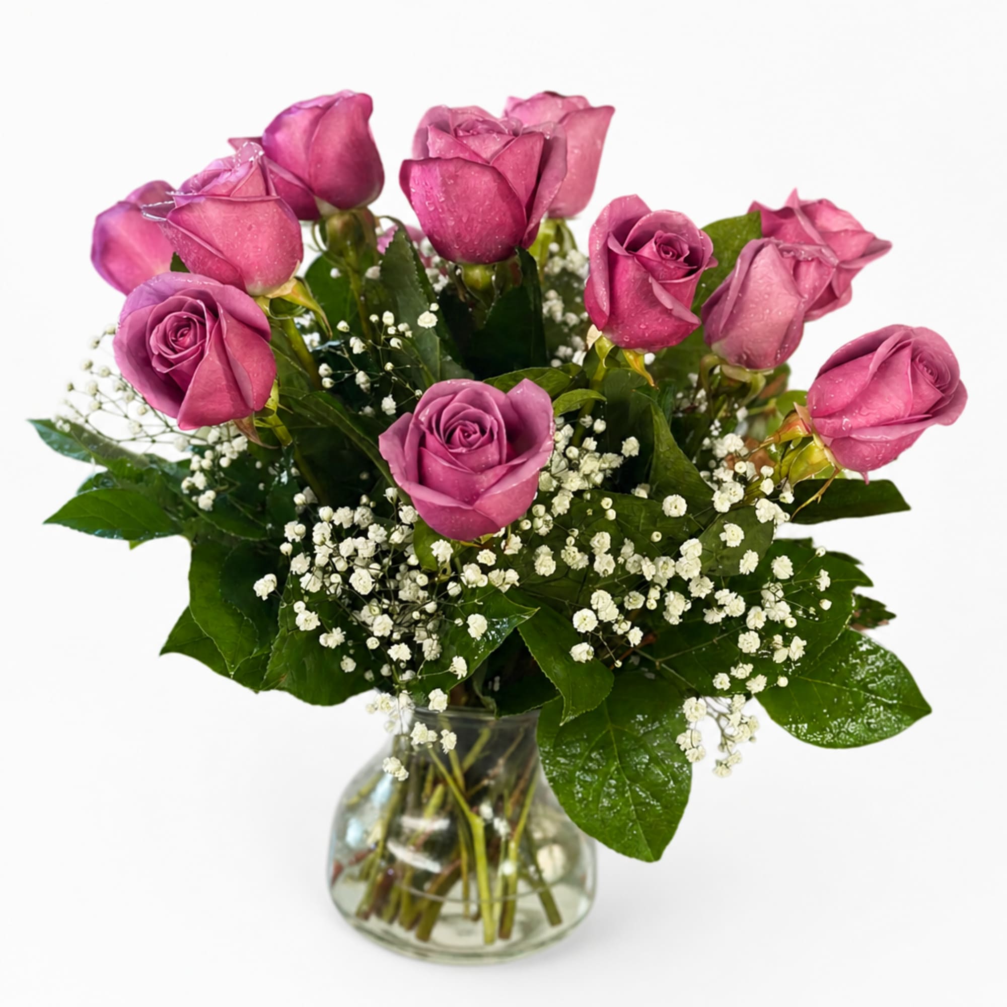 Pink roses arranged in a clear glass vase with white baby's breath