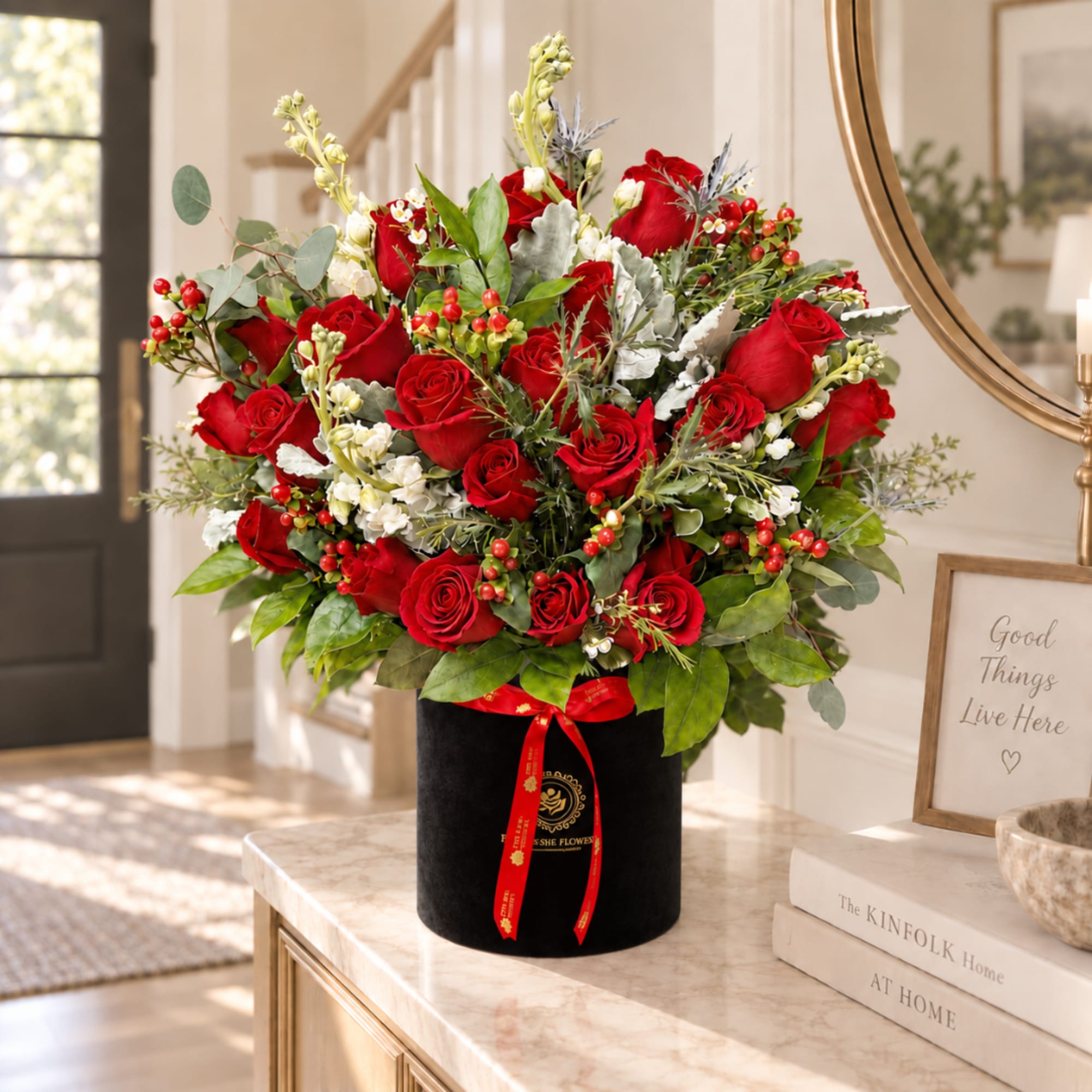 Large bouquet of red roses in a black velvet box with a red ribbon