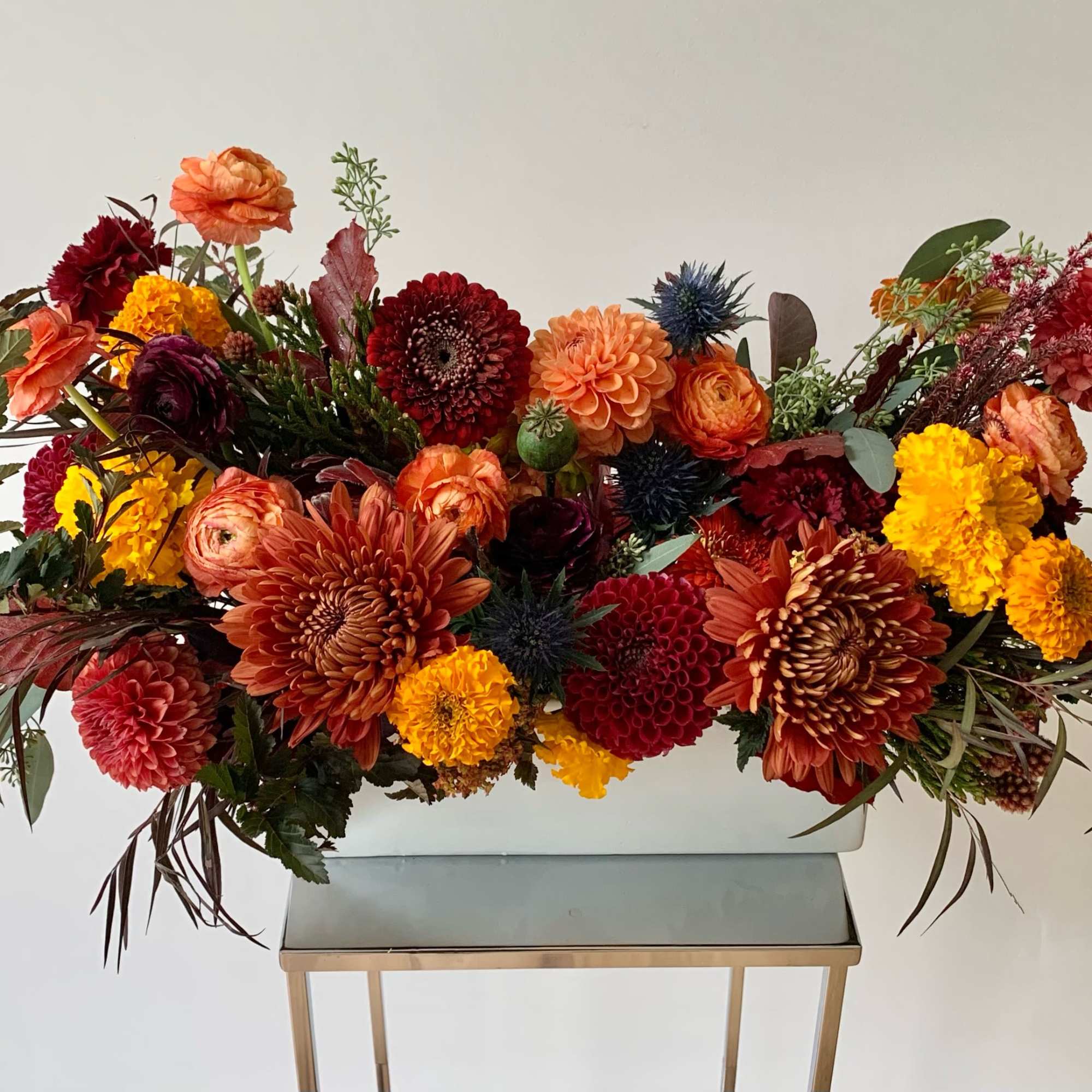 Large autumn flower arrangement in a white rectangular container