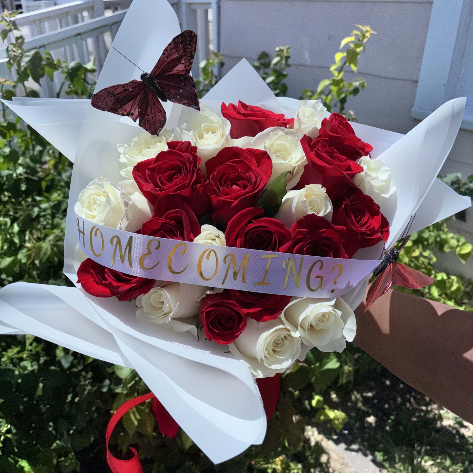 Bouquet of red and white roses with a butterfly and ribbon