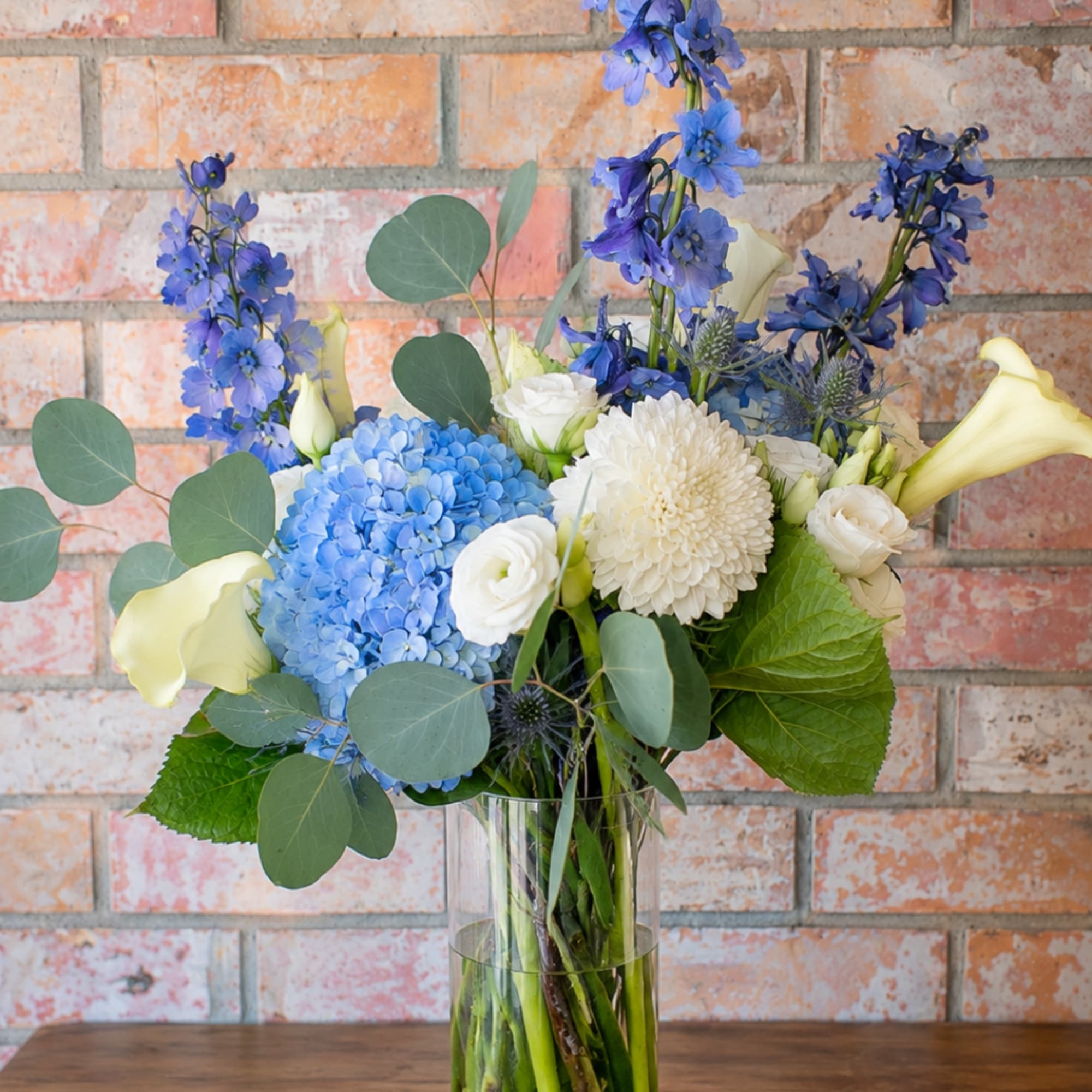 Blue and white mixed bouquet in a clear glass vase