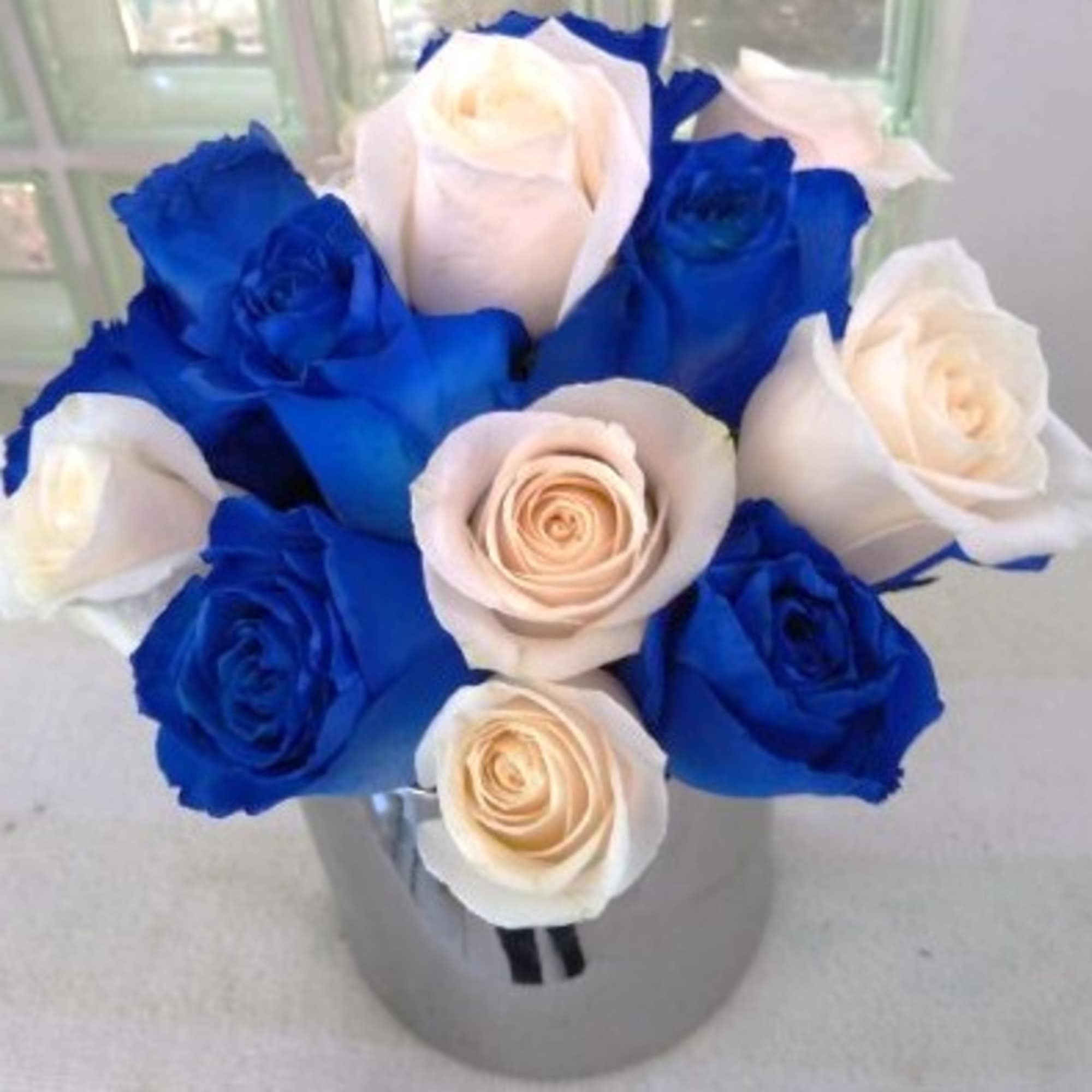 Blue and white roses arranged in a clear vase