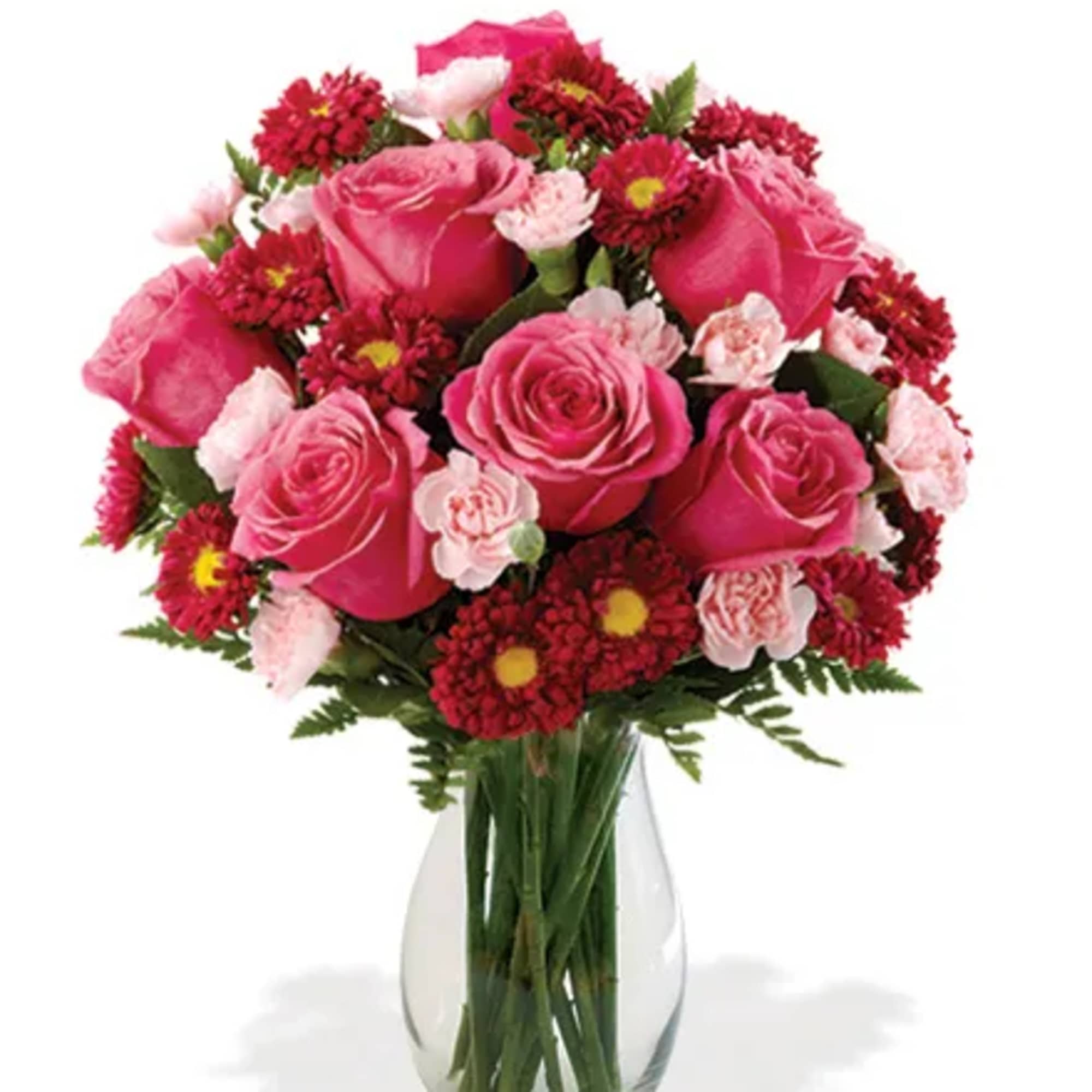 Pink roses and red daisy flowers in a clear glass vase