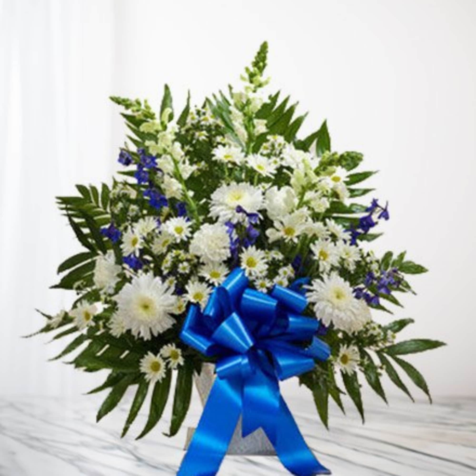 White and blue floral arrangement with a large blue ribbon