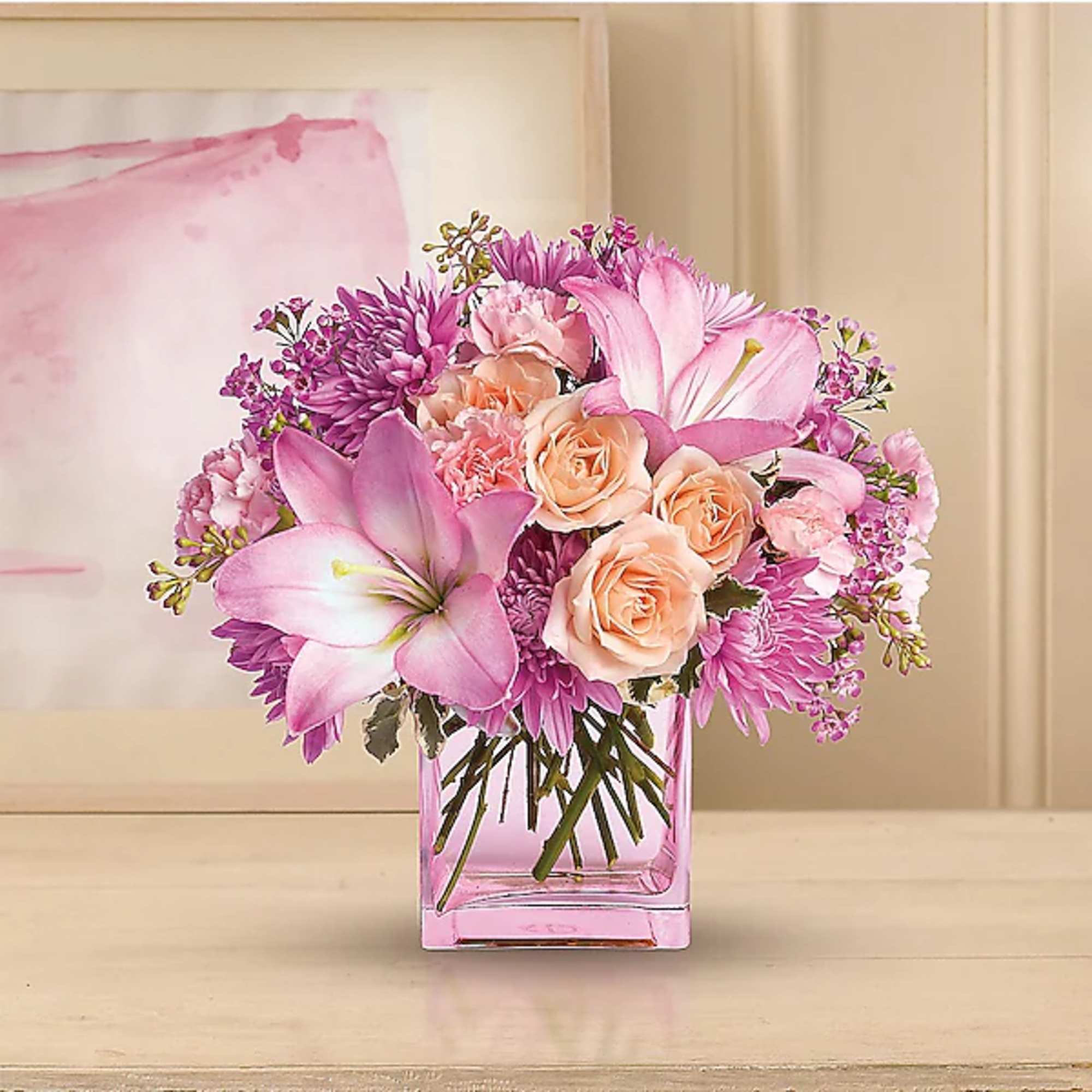 Pink and peach bouquet in a square glass vase
