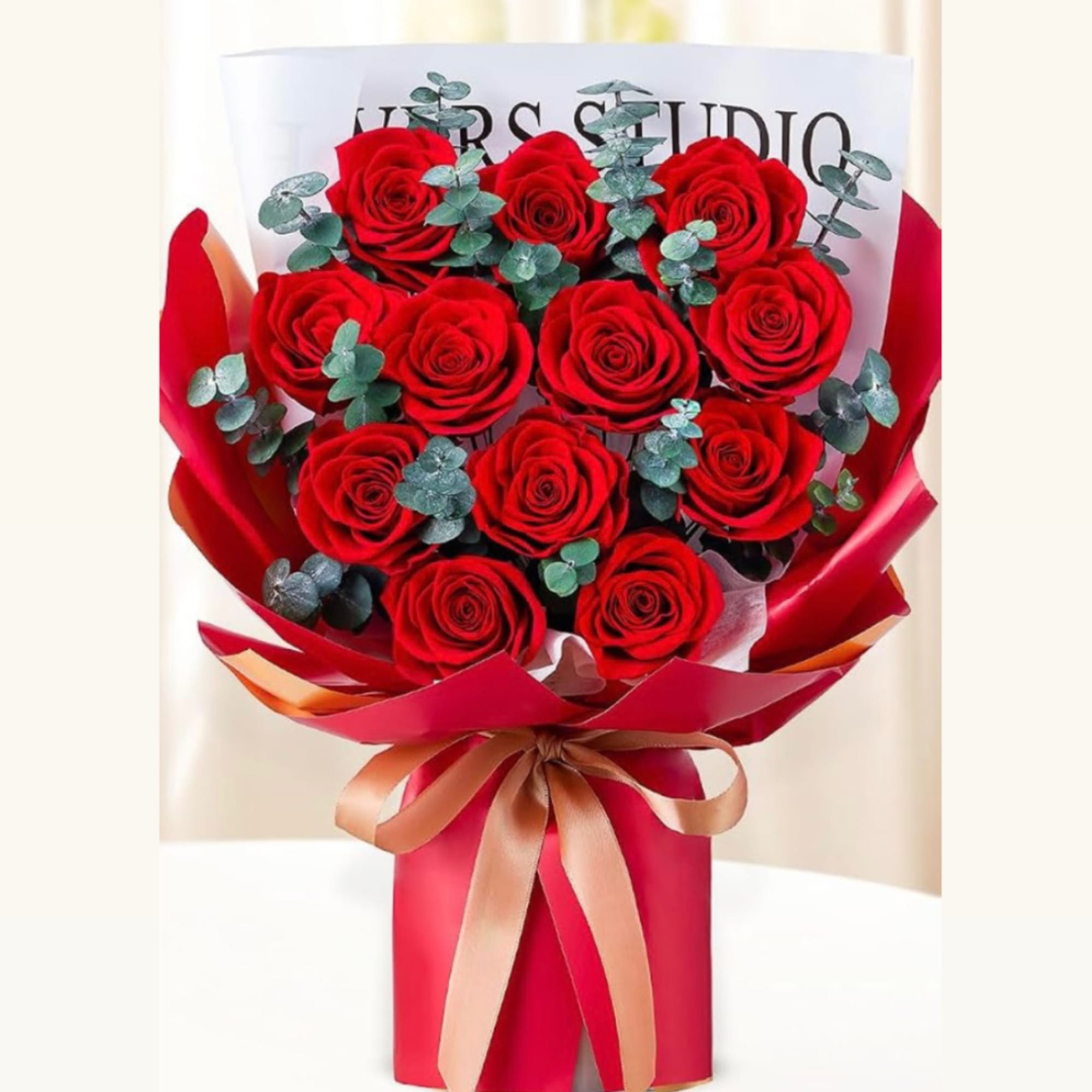 Bouquet of red roses wrapped in red paper with a ribbon