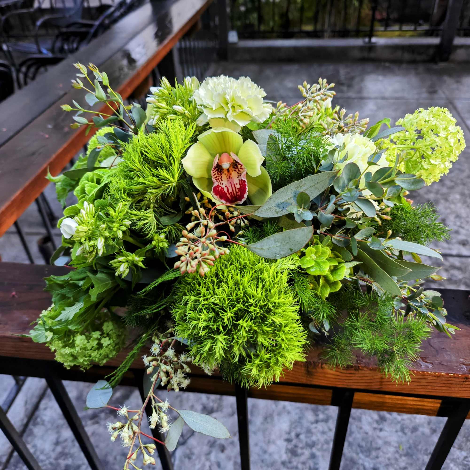 Shades of green flowers and foliage in a round centerpiece for the
