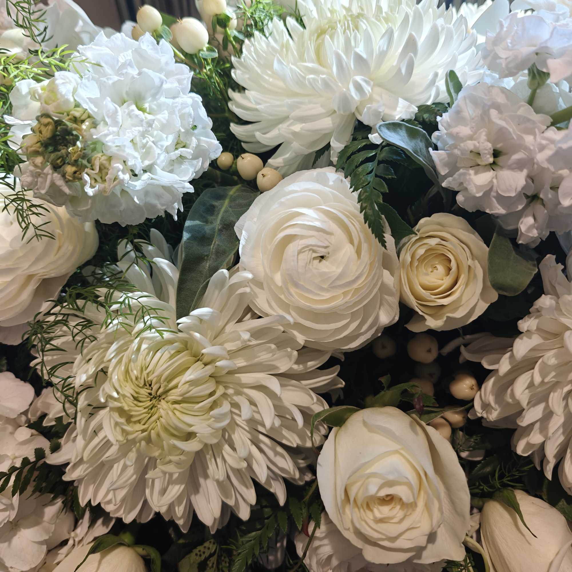 White floral bouquet with roses, chrysanthemums, and small berries