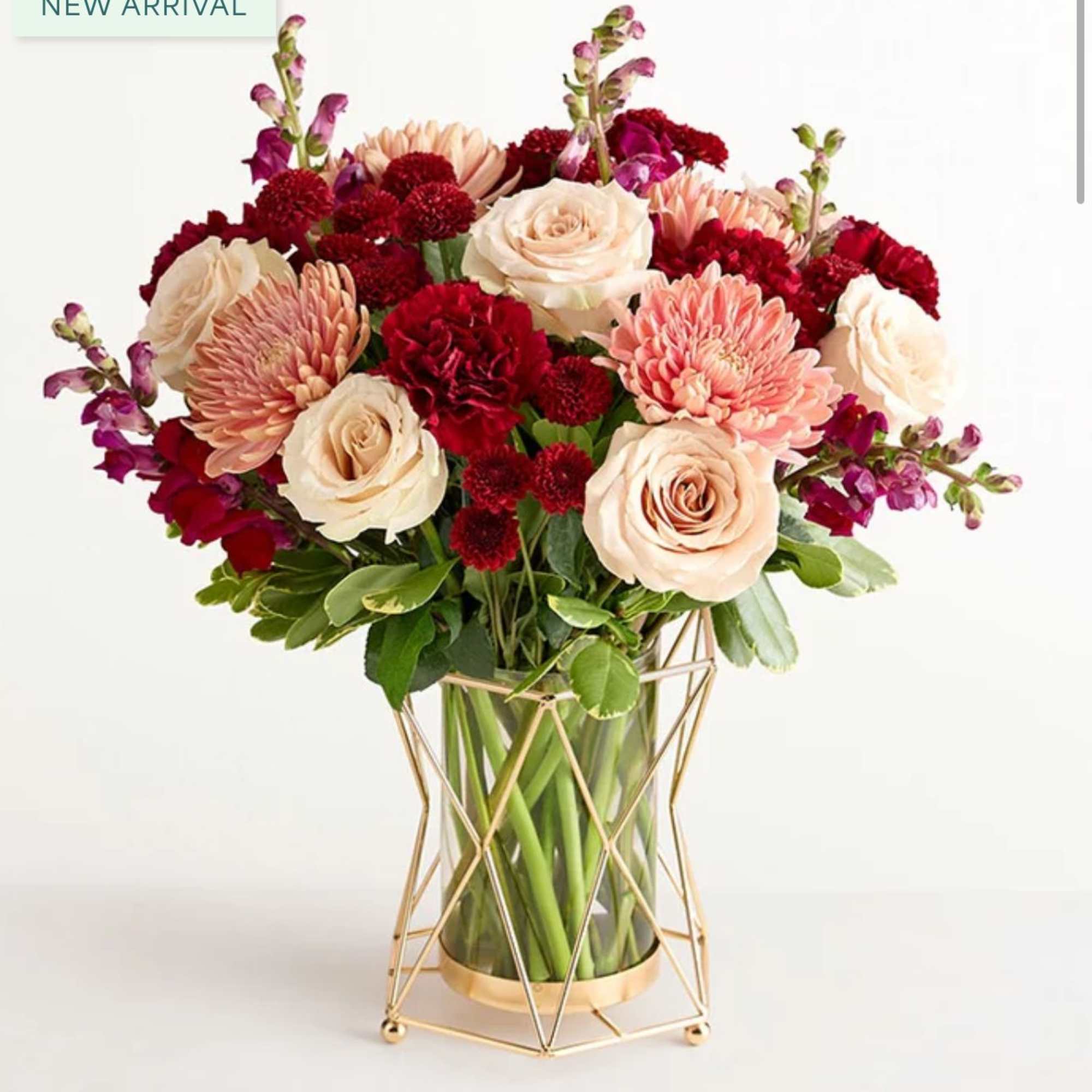 Bouquet of cream and red flowers in a glass vase with a gold stand
