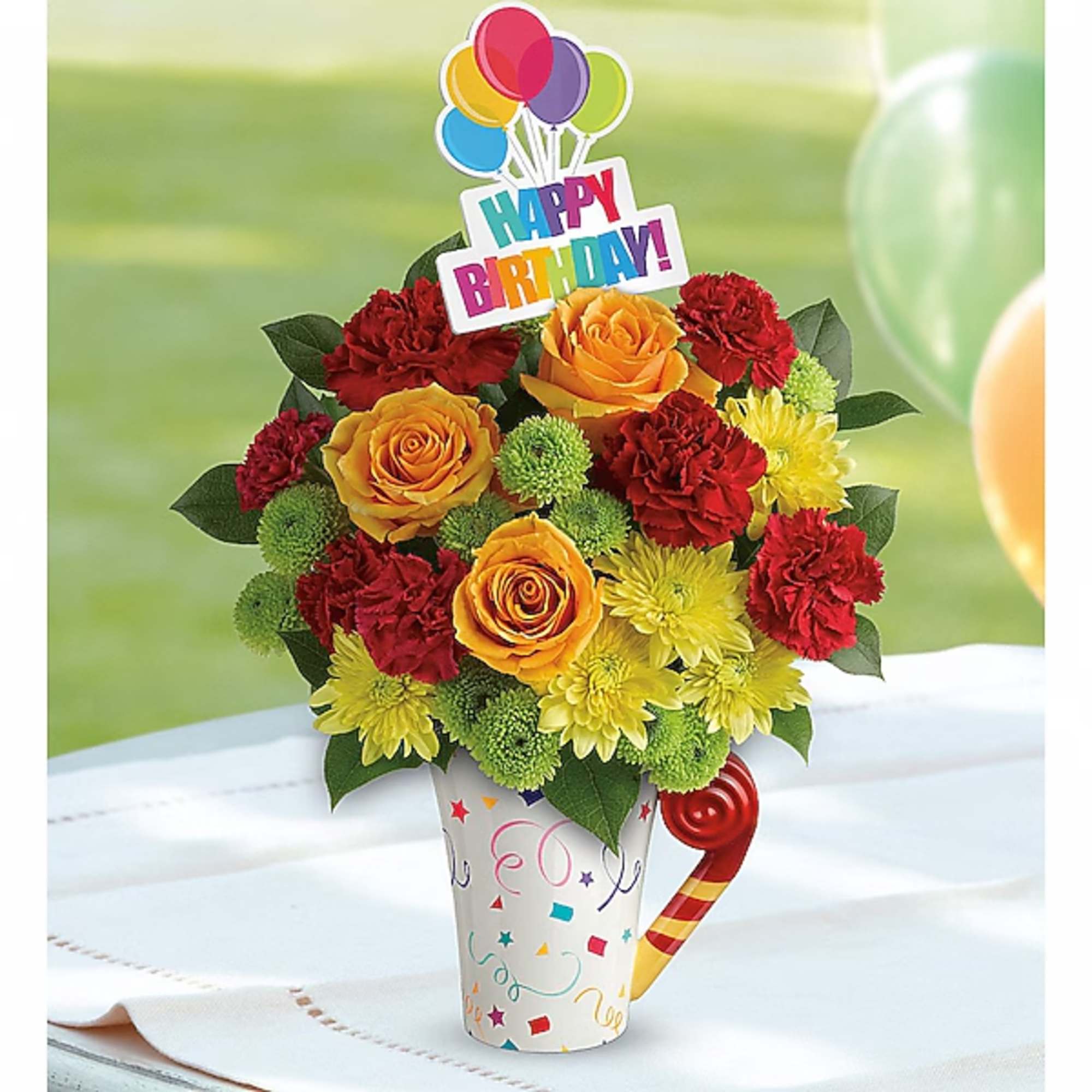 Birthday flower arrangement in a decorated mug with a Happy Birthday topper