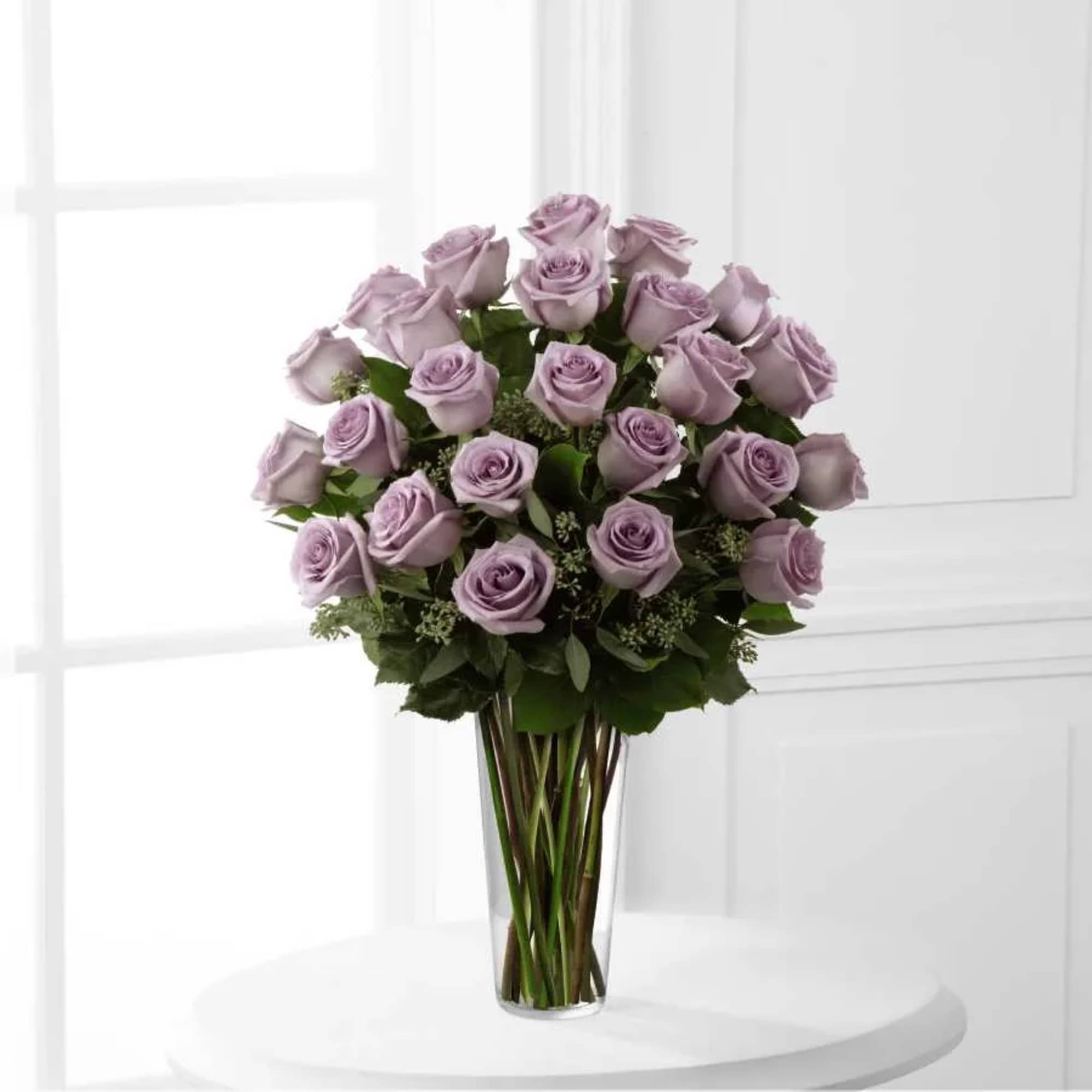 Lavender roses arranged in a clear glass vase