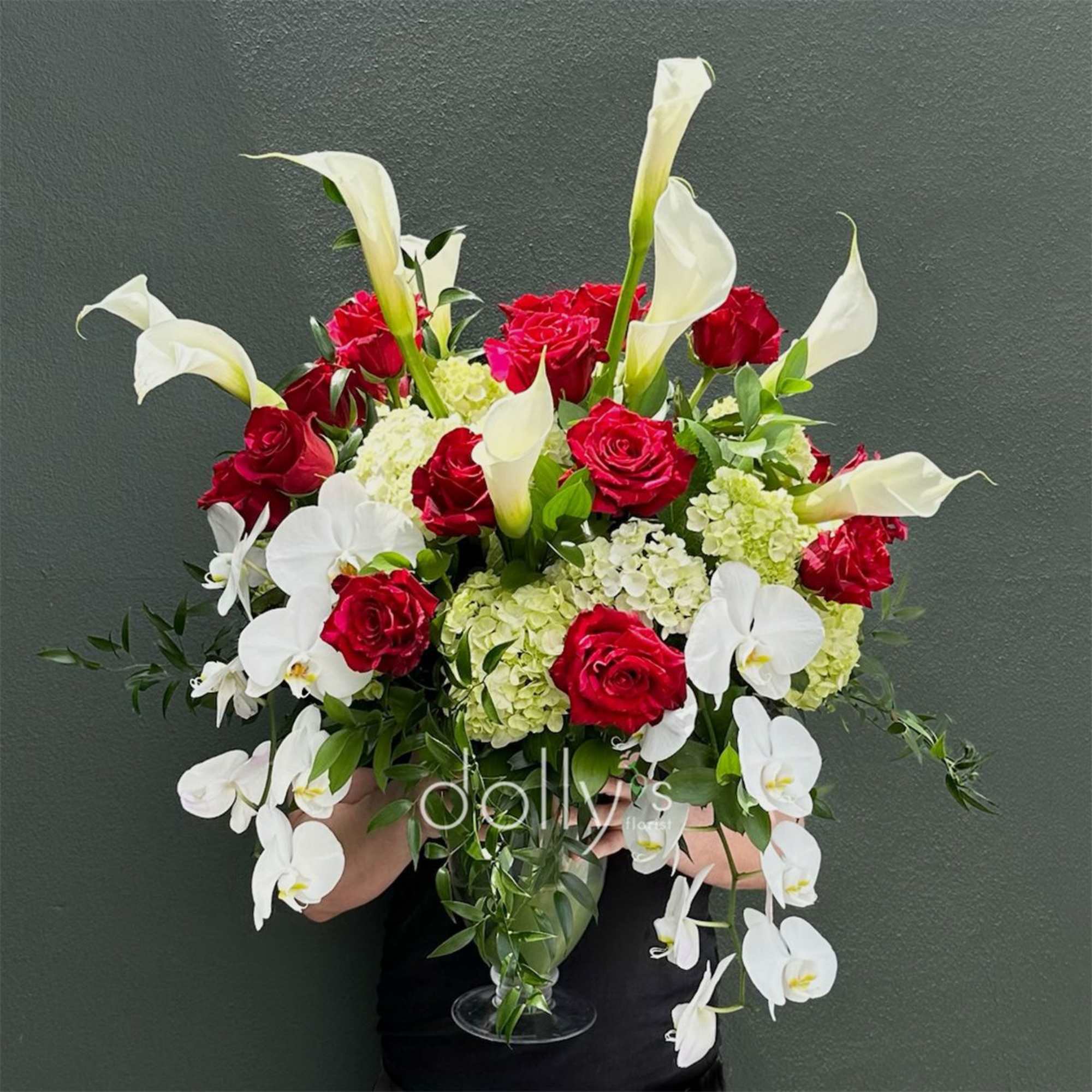 Red panther roses clustered against tall white calla lilies and cascading white
