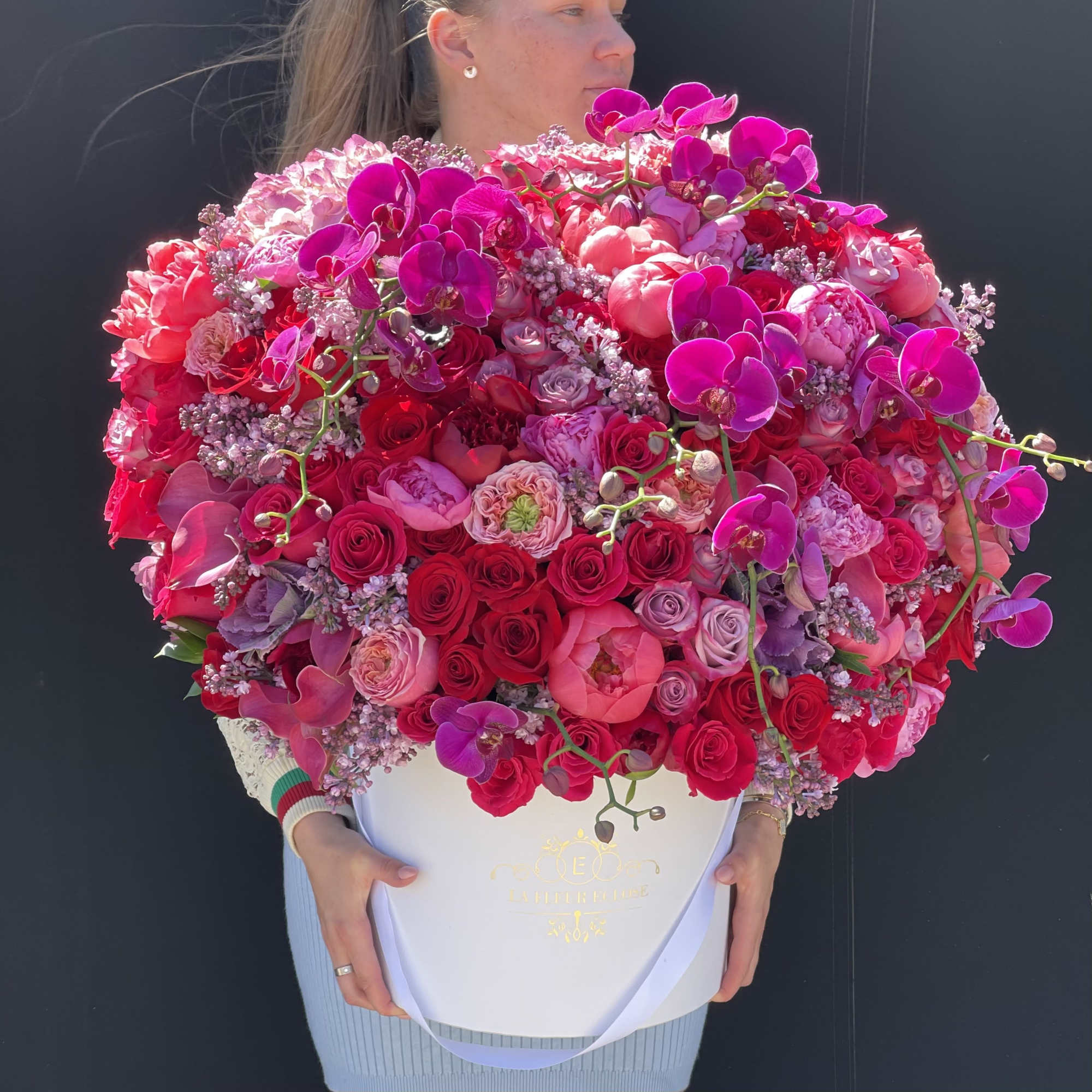 Large pink and magenta floral arrangement in a white box