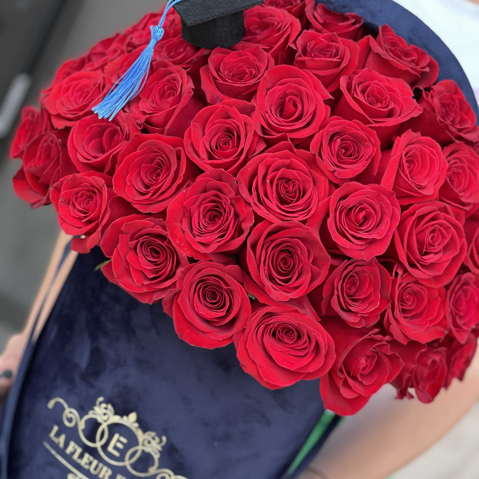 Bouquet of red roses with a graduation cap topper