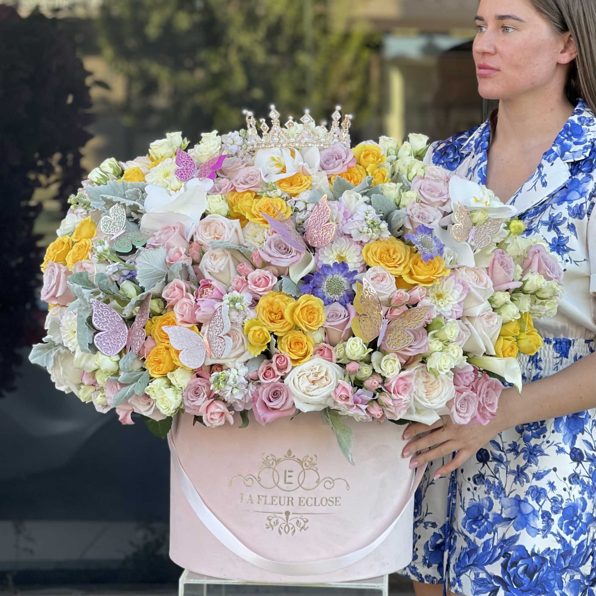 Large pastel bouquet in a pink hatbox with a jeweled crown topper