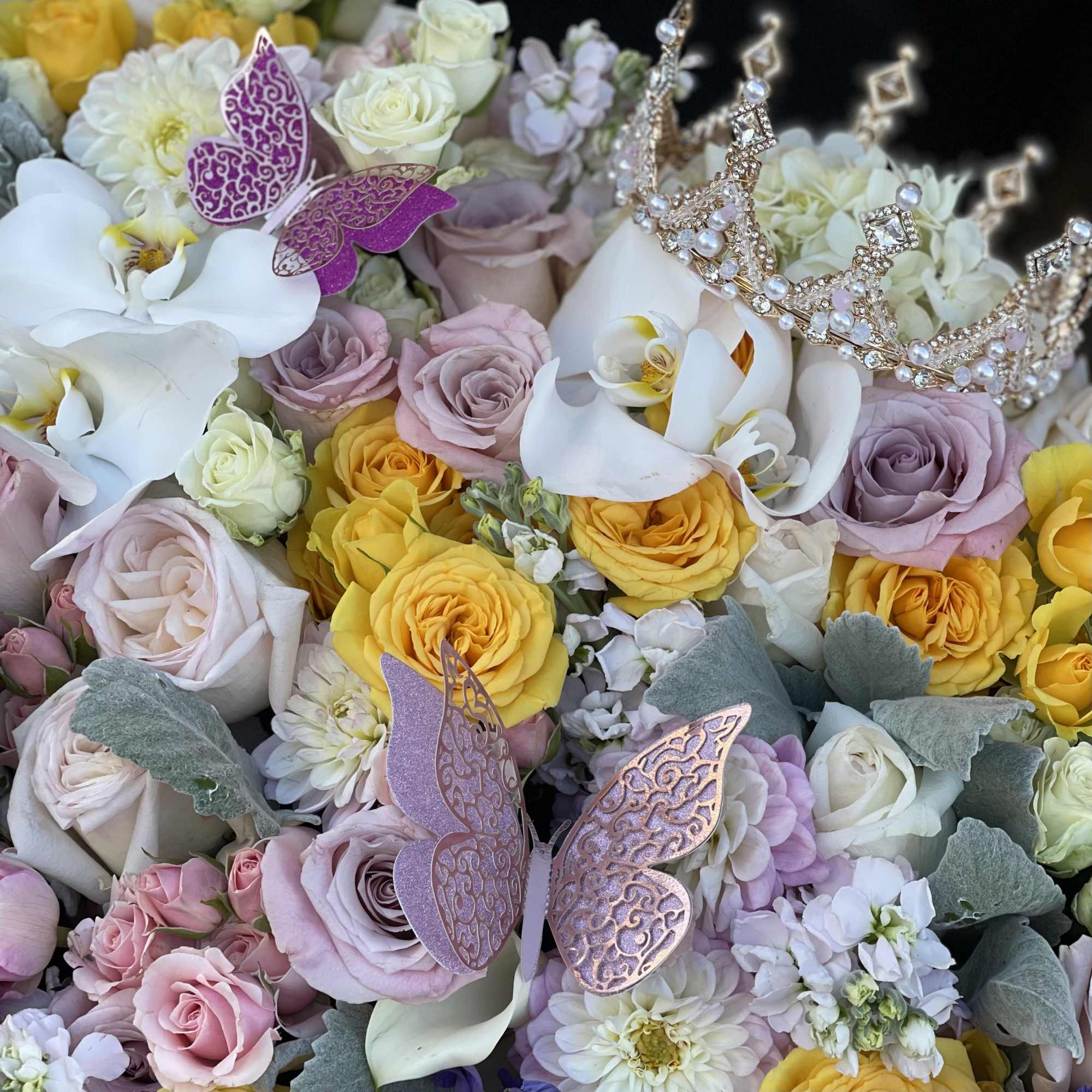 Bouquet of pastel roses and white calla lilies with jeweled tiaras and butterfly picks